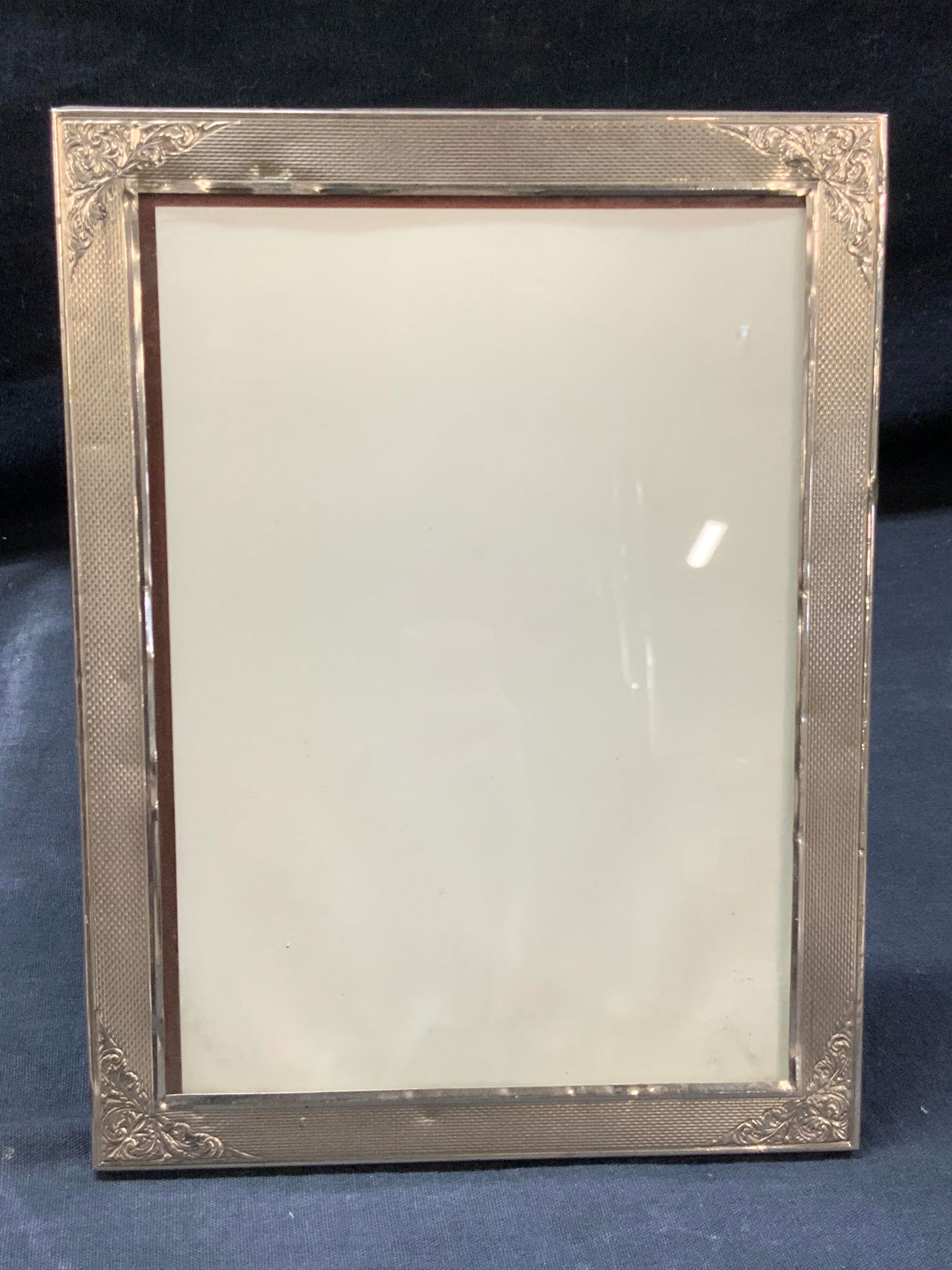 French Style Etched Sterling Silver Picture Frame: Sterling silver marked picture frames with wooden easel backing. Etched corners with French style scroll and floral motifs. Approx 8 x 6 inches. Marked 925 on edge. Total weight 7.84 ozt. Moderate to