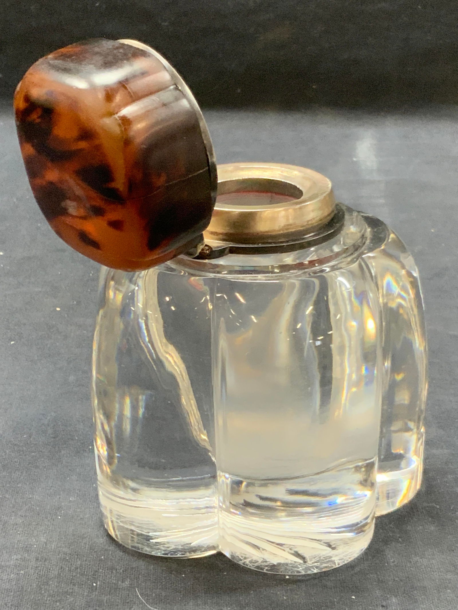 Vintage Bakelite Lidded Crystal Ink Well: Vintage solid crystal made ink well with a flower shape exterior with a hinged lid, possibly made of speckled Bakelite with a steel inner rim. Approx 5 inches tall and 4 inch wide base. Evident wearin