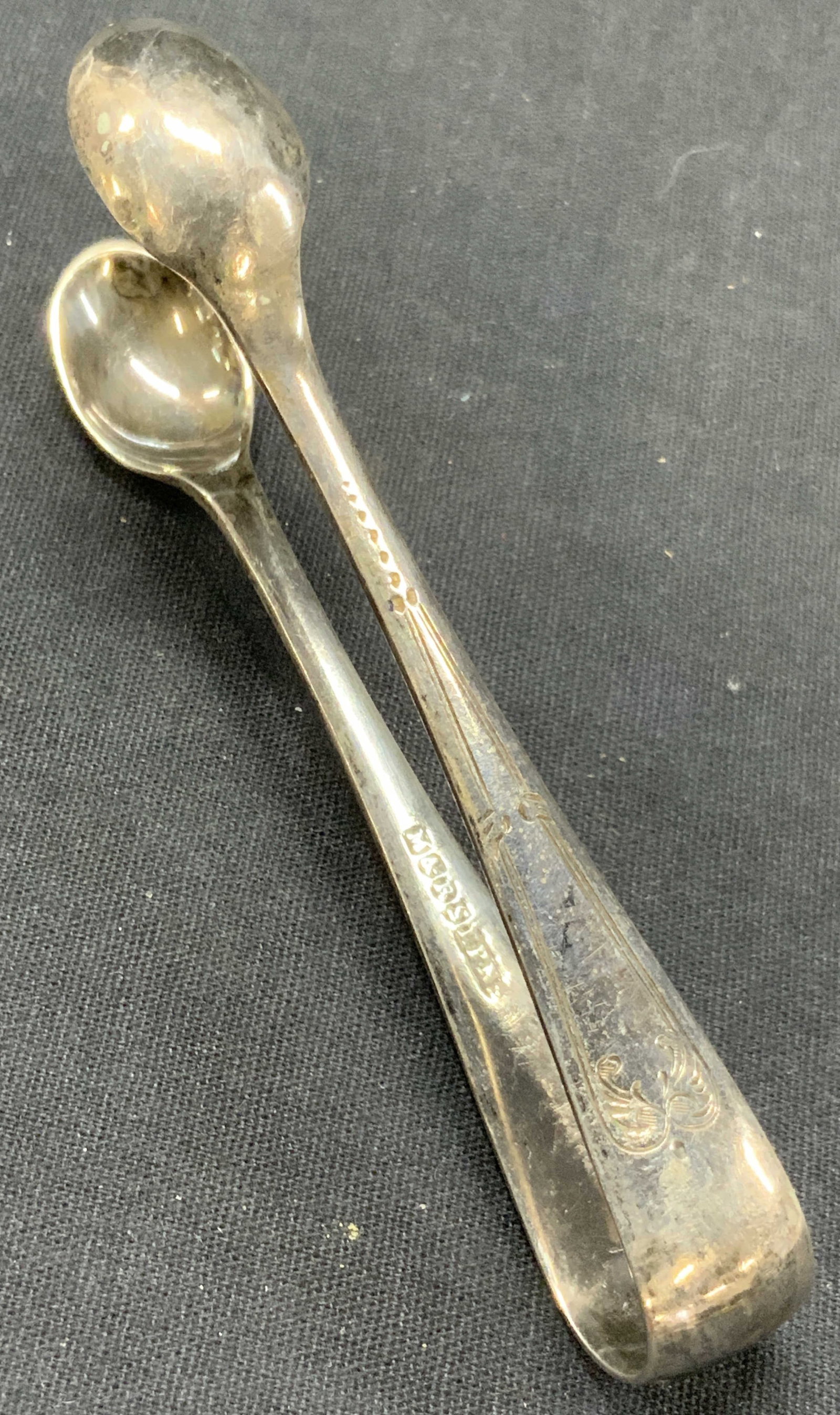M&R Silver Plate Vintage Etched Tongs: Stamped M&R electro plated, pair of tongs with spoon ends, and etched with scroll deigns on exterior. Approx 4 inches long. Moderate surface wearing to plating. Vintage tongs. Vintage sugar cube tongs