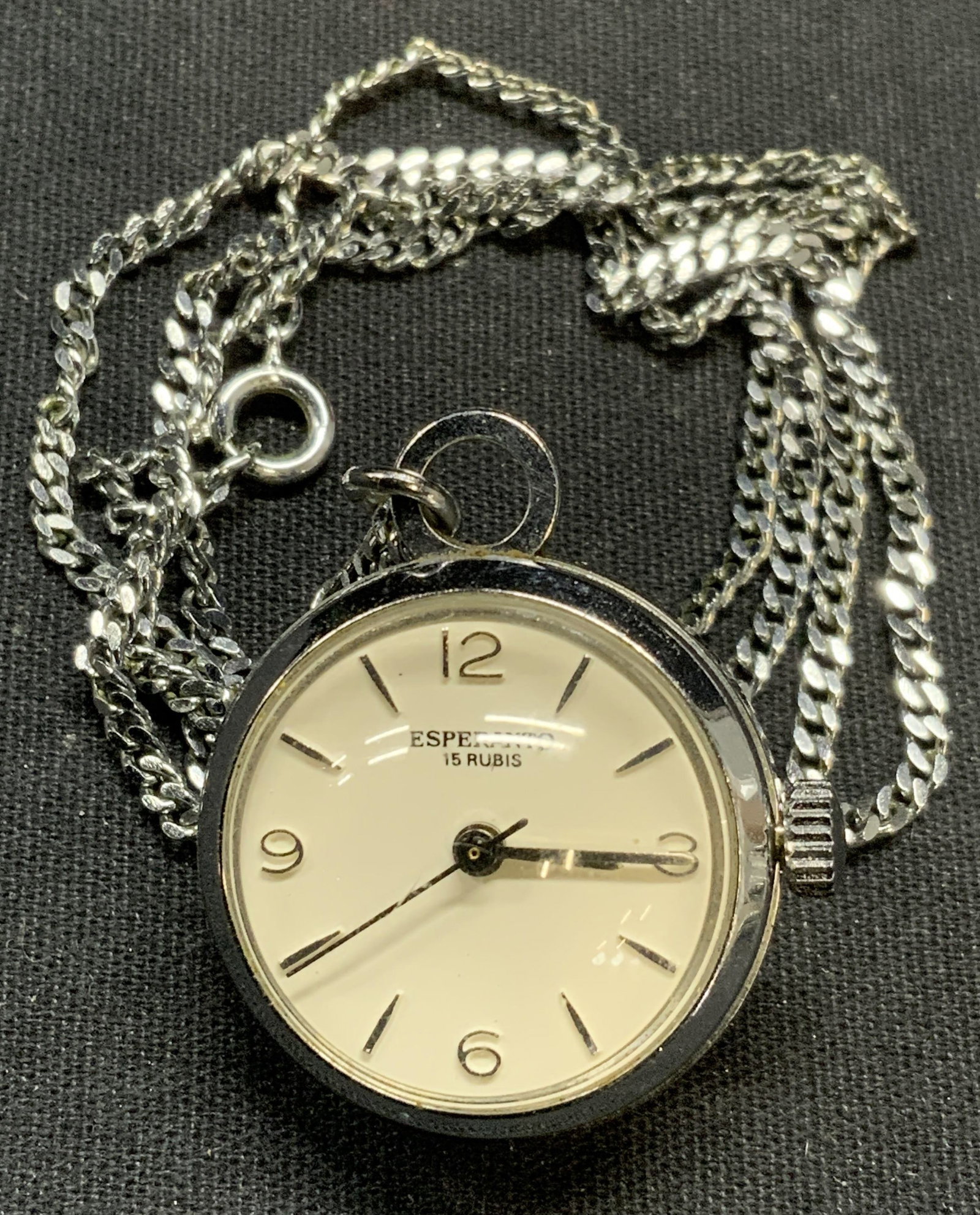 Esperanto Silver Tone Watch Pendant Necklace: Esperanto silver tone watch pendant on silver tone chain. Signed on watch face. Drop length approx. 13.5 inches. Watch measures approx. 1 inch diameter. Some scratching observed. Not tested for functi