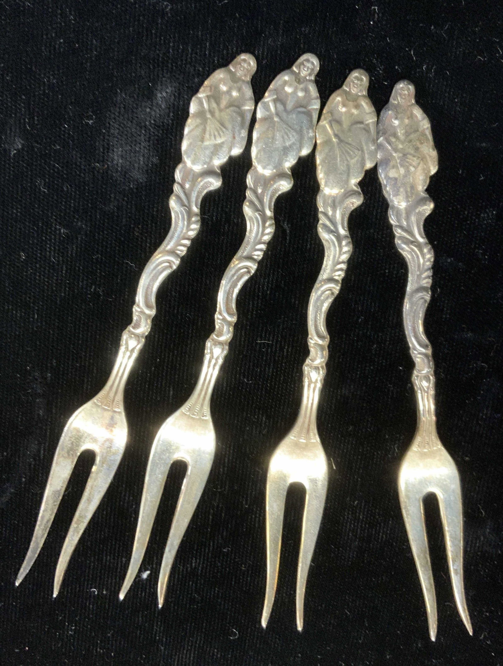 Set4 Sterling Silver Nouveau Cocktail Forks Sweden: Set 4 sterling silver cocktail forks with 2 prongs. Decorative art nouveau handle with the tip of a lady in a dress holding a fan. 1.12 ozt . 4 in. Long. Tests for sterling with PuriTEST kit. Marked S