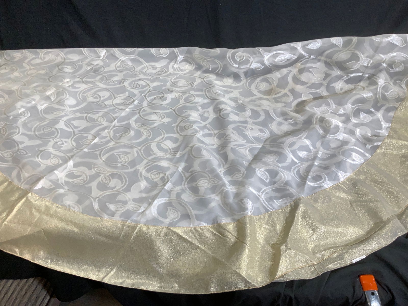 Round Sheer Tablecloth with Gold Trim: Scroll and leaf patter sheer round tablecloth with wide border metallic gold trim. 70 in. diameter. There are dark blemishes in one section. Up cycle . Property of Manhattan Estate DuPont Heir. Round