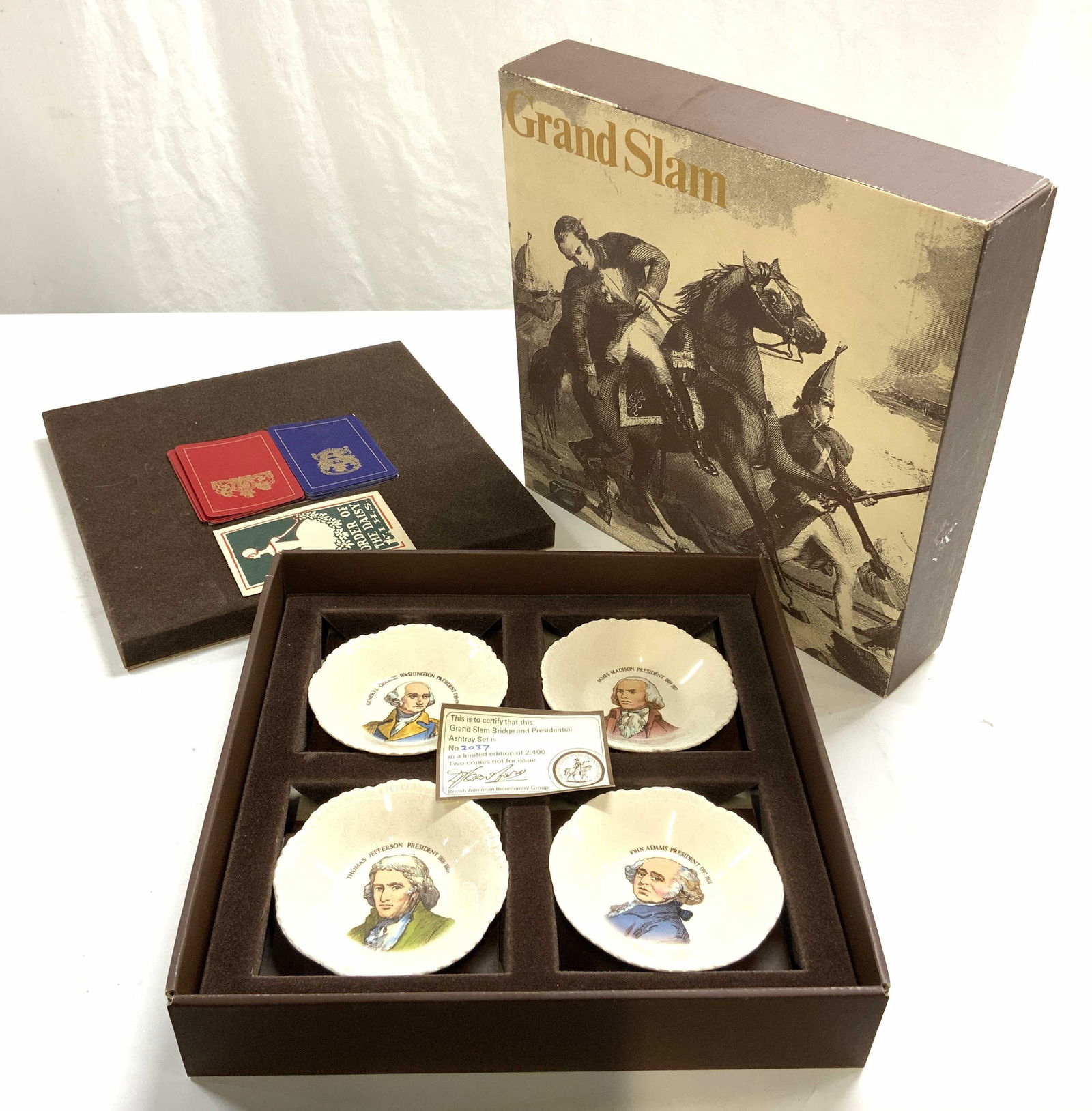 GRAND SLAM Bridge Cards & Presidential Ashtrays: Box reads GRAND SLAM. Lot includes blue & red toned backside bridge cards with gilt detail, 4 Porcelain Presidential ash trays including GEORGE WASHINGTON, JAMES MADISON, THOMAS JEFFERSON, & JOHN ADAM