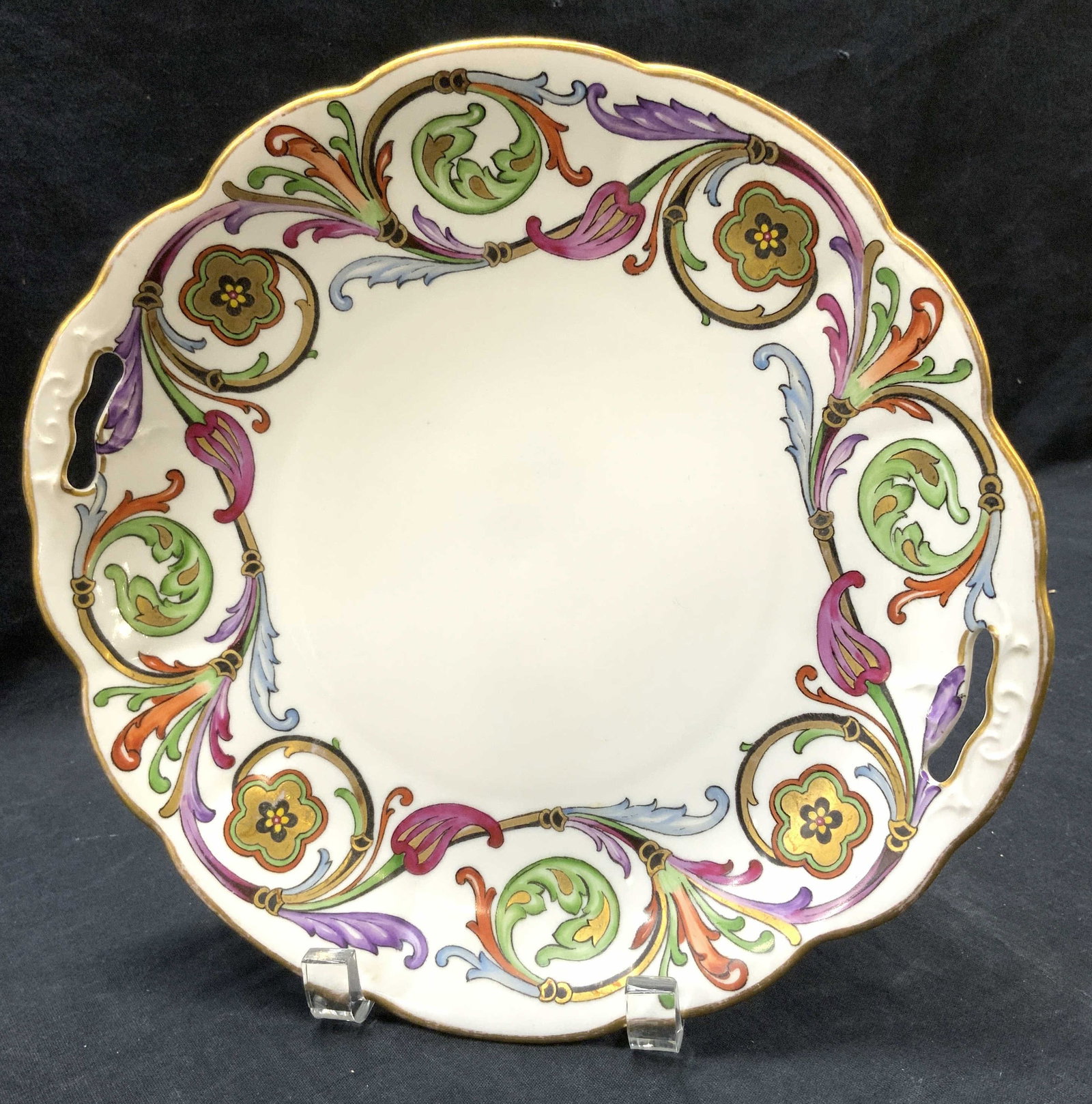 Antique Crown Saxe Painted Acanthus Plate, Germany: Antique serving plate hand painted with beautiful and vivid colored acanthus leaf scrolls. Colors of green, red, purple, & blue are accented with gilt. Gilt rim. Stamped in green ink with crown mark w