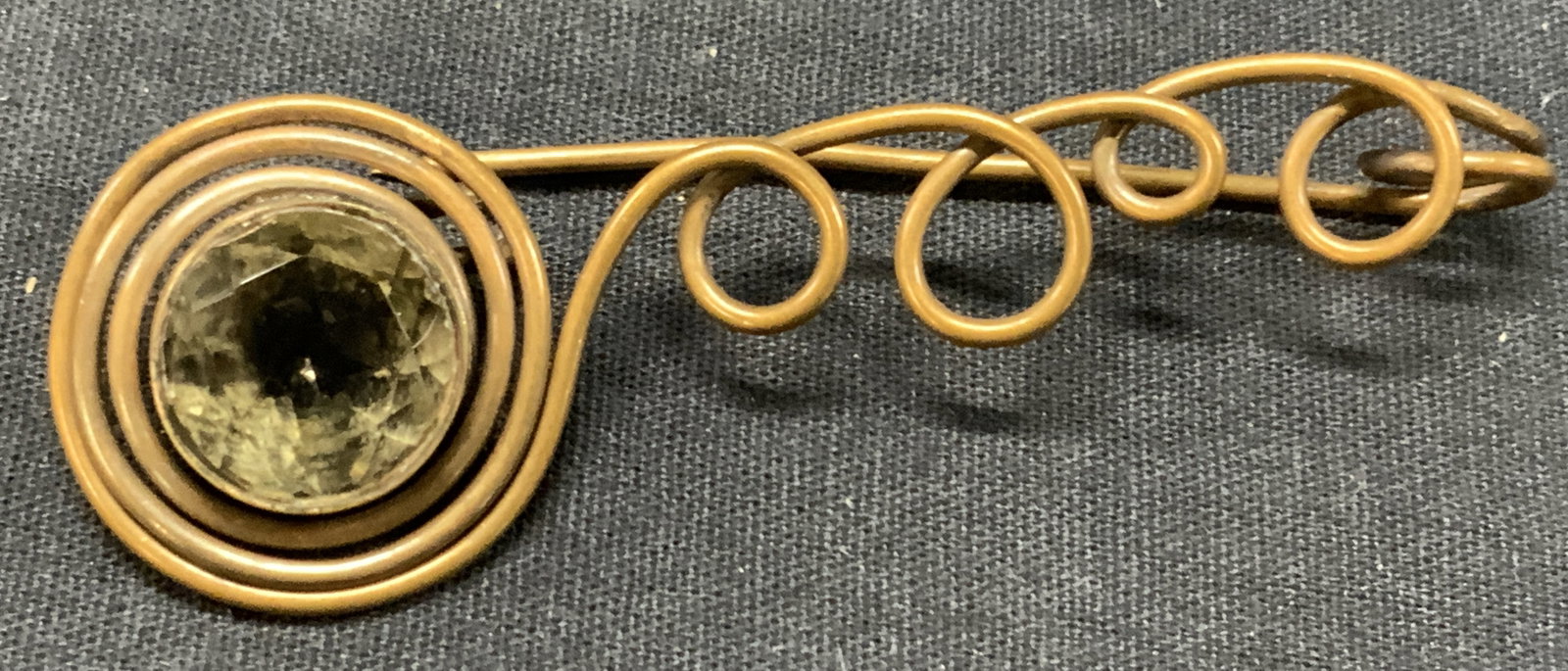 Copper Spiral & Quartz Brooch: Brooch with spiral designs made of copper with a solitaire cut Quartz in a bezel setting. Approx 3 inches long with the stone being 0.75 inches wide. Moderate wearing to metal and to spirals Copper br