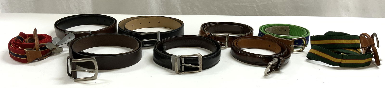 Lot 9 Leather Belts & Suspenders: Lot includes 6 leather belts 1 fabric belt, 1 red and navy pair of suspenders, & 1 green & yellow pair of suspenders. 2 belts are reversible. Largest belt measures approximately 30 inches long. Includ