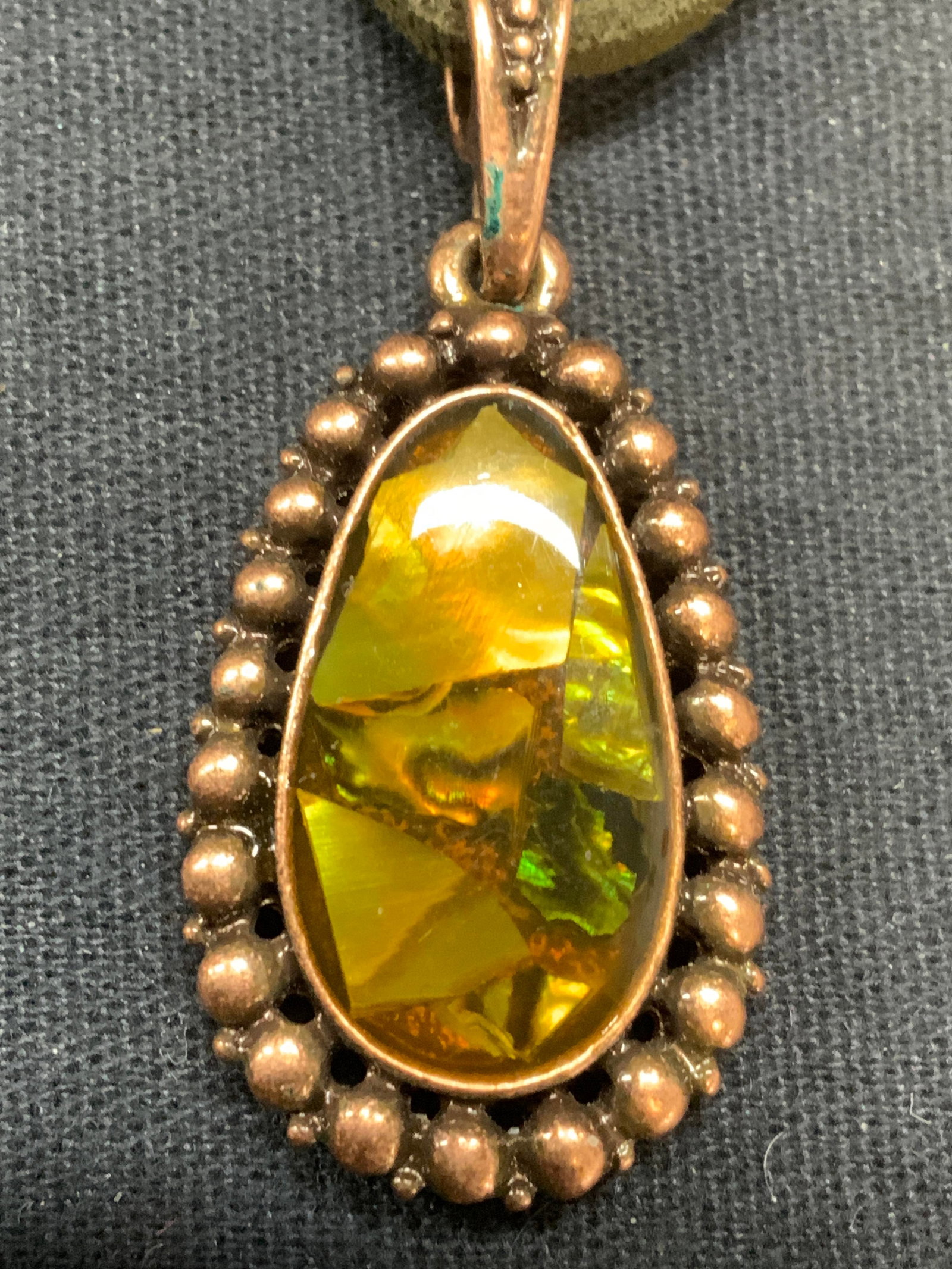 Signed 1928 Gold Tn Shell Pendant Necklace: Signed 1928 gold tone and green toned shell pendant on green cord. Signed 1928 on hang tag. Drop length approx. 9 inches, pendant approx. 1.75 x .5 inches. Some scratching observed. Estate jewelry, co