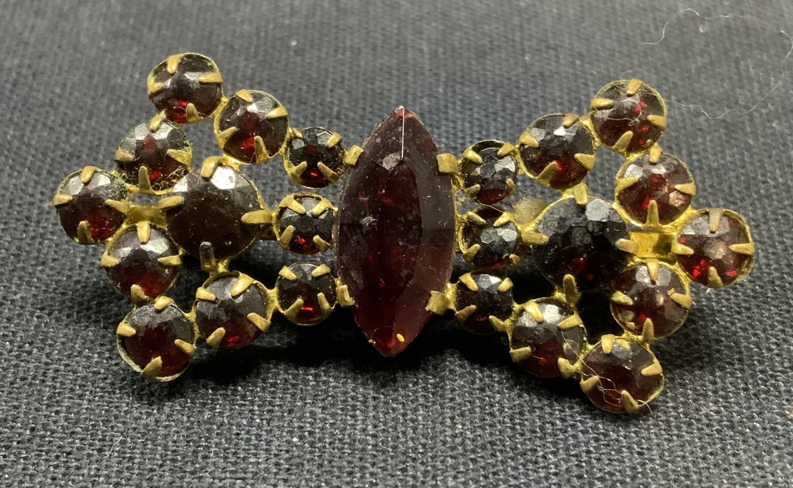 Vintage Gold tn Red Crystal Bow Brooch Czech: Vintage gold tone bow brooch with red crystal decoration. Marked Czechoslovakia to underside. Hinge pin to underside. Measures approx. 7/8 x 1.75 inches. Some scratching observed. Estate Jewelry, cost