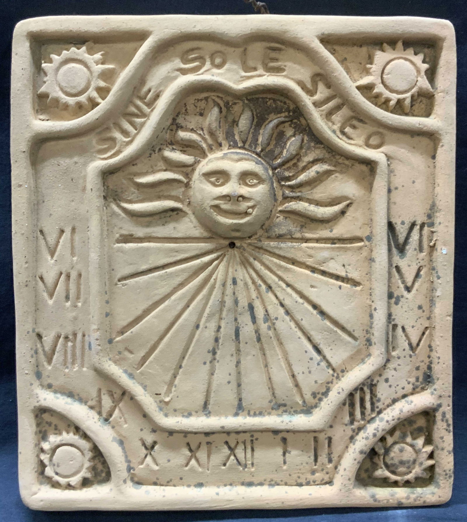 Terracotta Sine Sole Sileo Wall Plaque: Terracotta clay crafted wall plaque with the words Sine, Sole, Sileo on the top half, with a motif of a sun with Roman numerals etched within the clay. Approx 10 x 9 inches. Moderate discoloration and