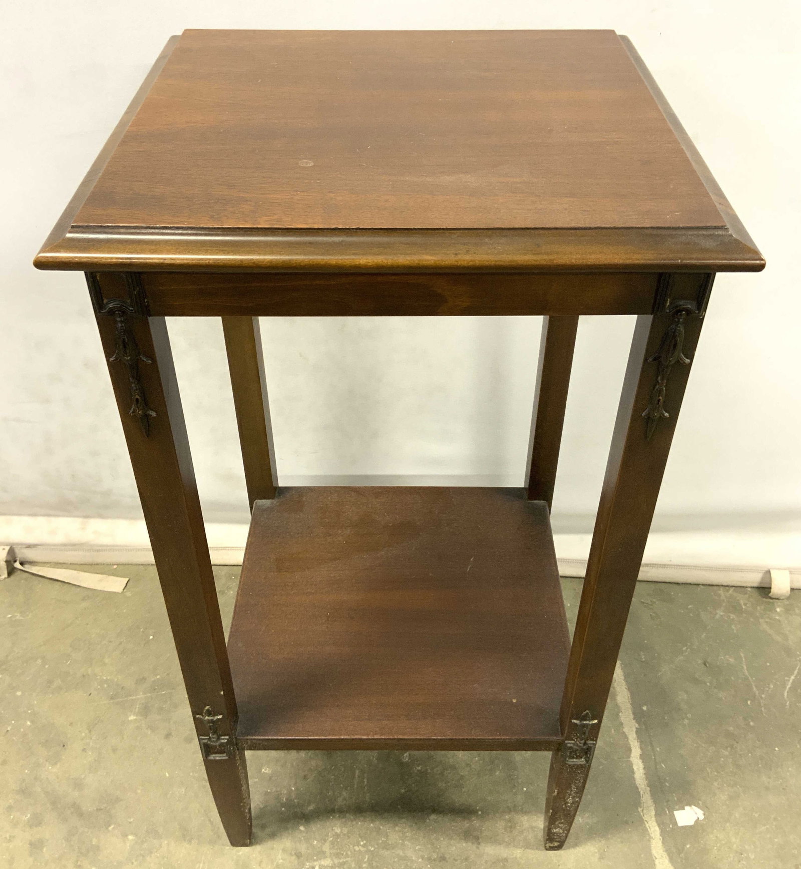 Vintage Carved Wooden Side Table: Side table is vintage and wooden. Piece is brown toned. Table has 4 legs with board stretcher in between. Table legs have areas of intricately carved detail. Measures approx 30 inches tall 16 inches w
