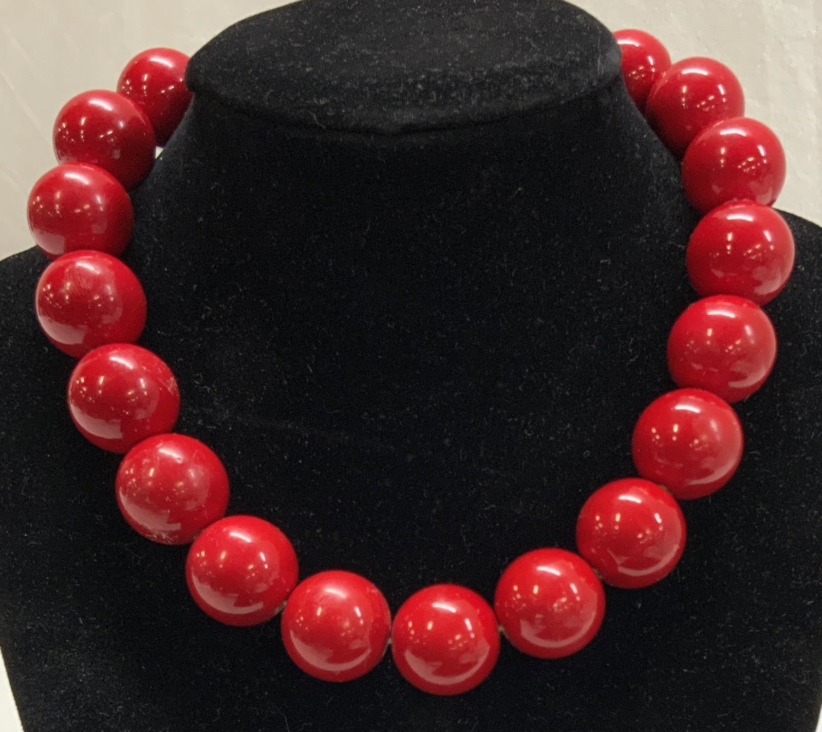 Lightweight Red Lacquered Bead Necklace: Lightweight red lacquered round bead necklace/ choker necklace, adjustable length . Each bead measures 5/8 in. Drop is 4.5 in. - 6.5 in. Minor chipping of paint on some beads, unremarkable Red bead ne