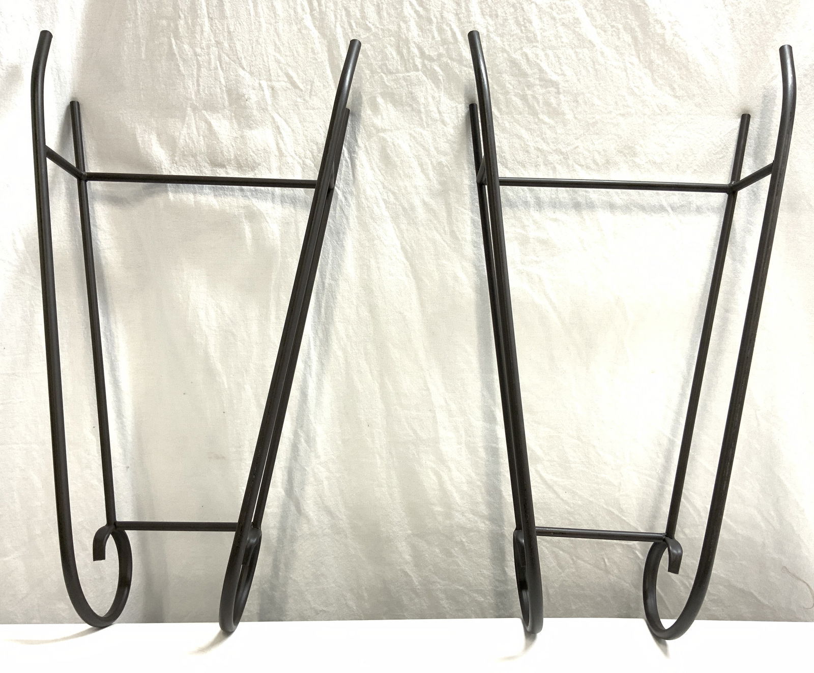 Pair Of Metal Decorative Objects 26in: Lot includes 2 decorative objects. Each are brown toned and metal. One end of each piece has curled structures. Each piece measures approximately 26.5 inches tall 14.5 inches wide 6 inches deep. Decor