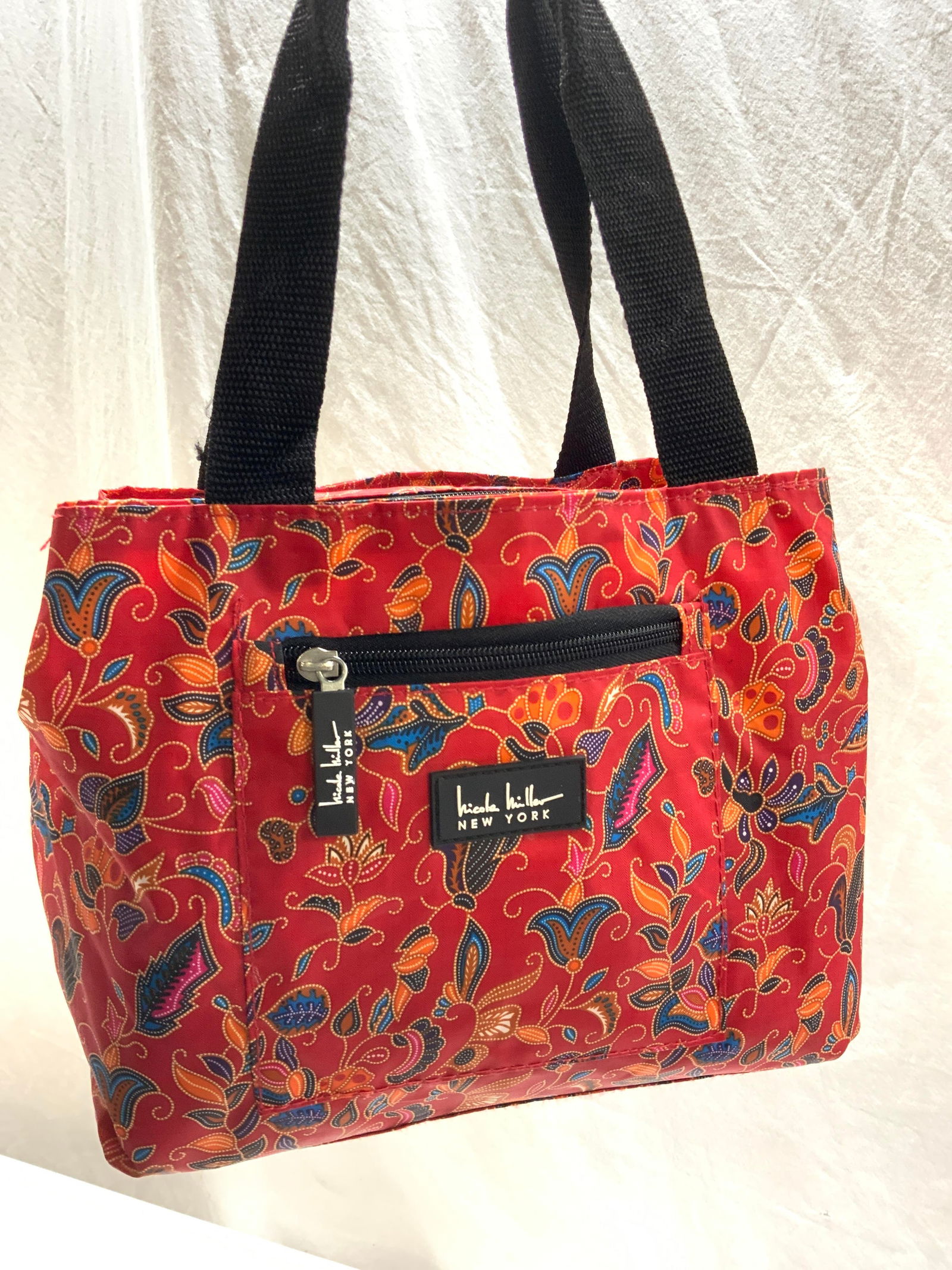 Nicole Miller Lunch Bag: Nicole Miller New York Lunch bag with handles. Handle drop is 8 in. Wipeable polyester. Zipper front pocket, zippered interior flanked by 2 open compartments the size of the bag. Open wide., 10.5 in.