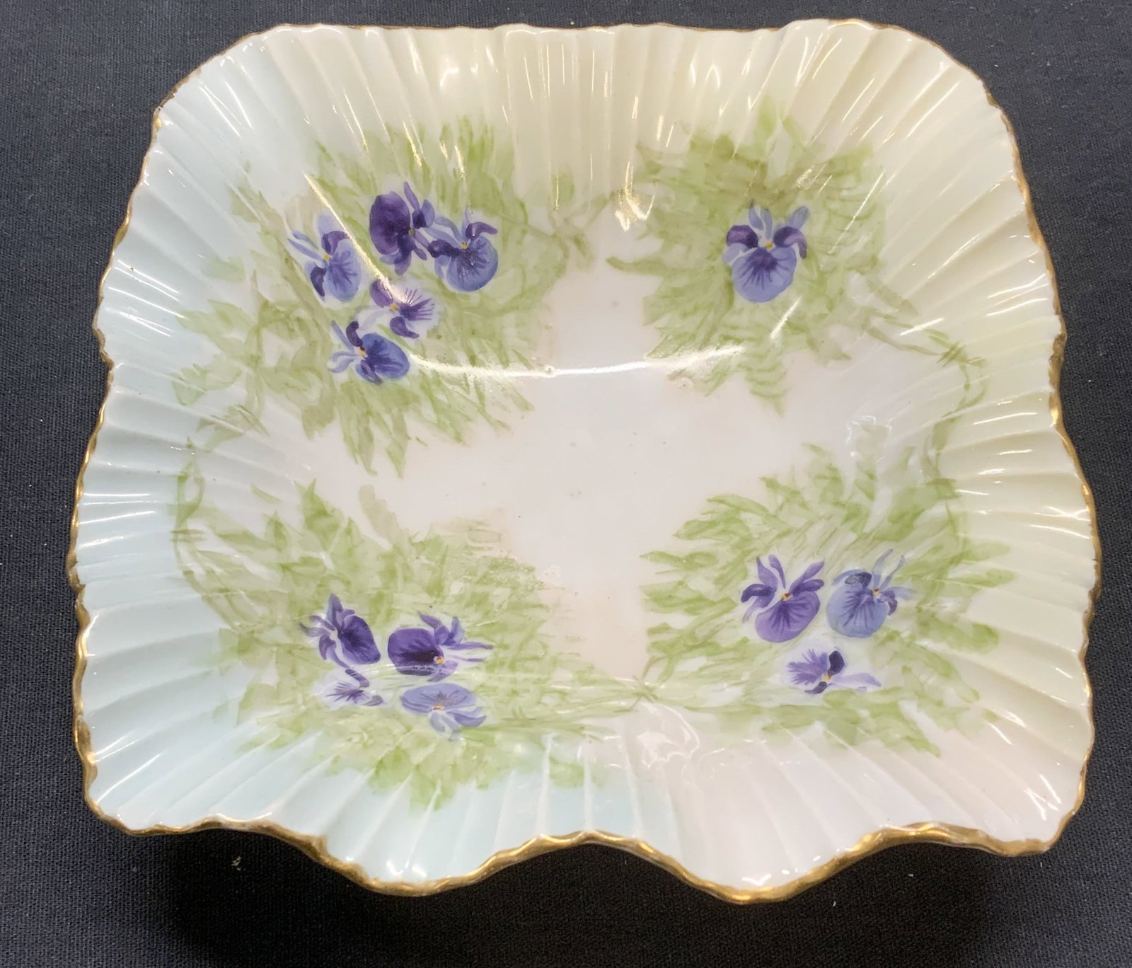 Vintage Porcelain Floral Handkerchief Dish: Vintage porcelain dish. Square shaped with raised ribbed border. Hand painted gilt decoration and floral motif. Handkerchief rim. Measures approx. 6 x 6 x 1.75 inches. Some scratching observed. Porcel