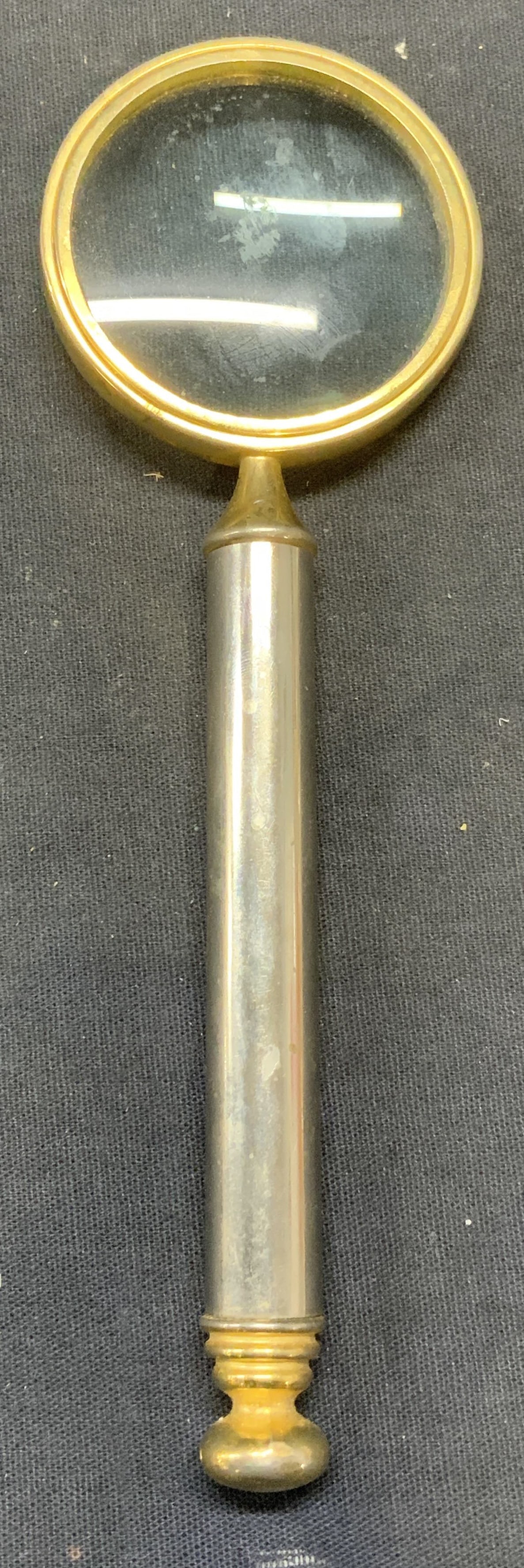 Silver & Gold Tone Magnifying Glass: Silver and gold toned magnifying glass. Measures approx. 6.5 x 2 1/8 inches. Some surface wear including scratching observed. Magnifying glass, silver tone magnifying glass, gold tone magnifying glass
