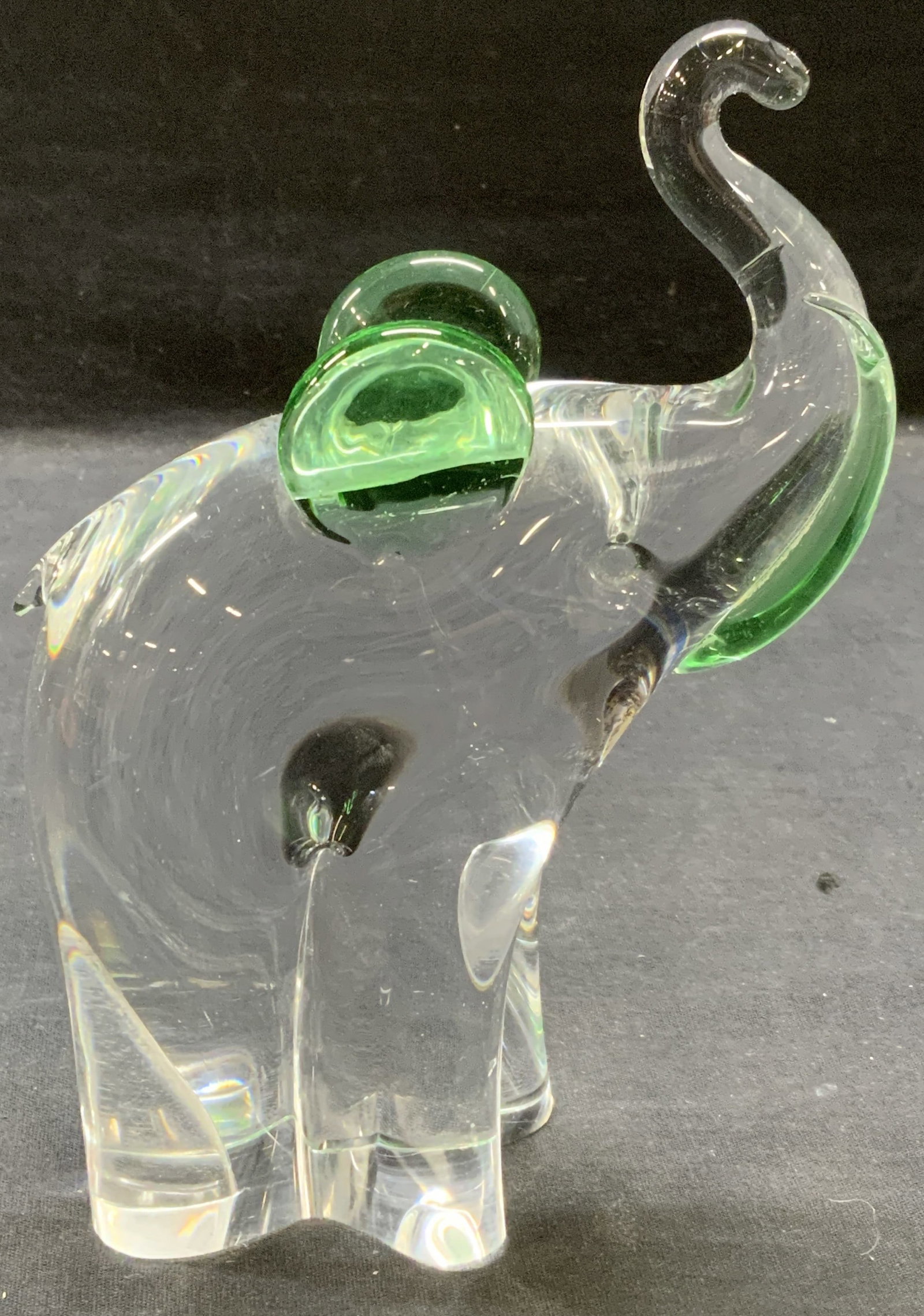 Hand Blown Art Glass Elephant Figural: Hand blown art glass elephant figurine. Green to clear glass. Thick walled glass, piece has weight. Measures approx. 5.25 x 2 x 7.25 inches. Some surface wear including scratching observed. Art glass,