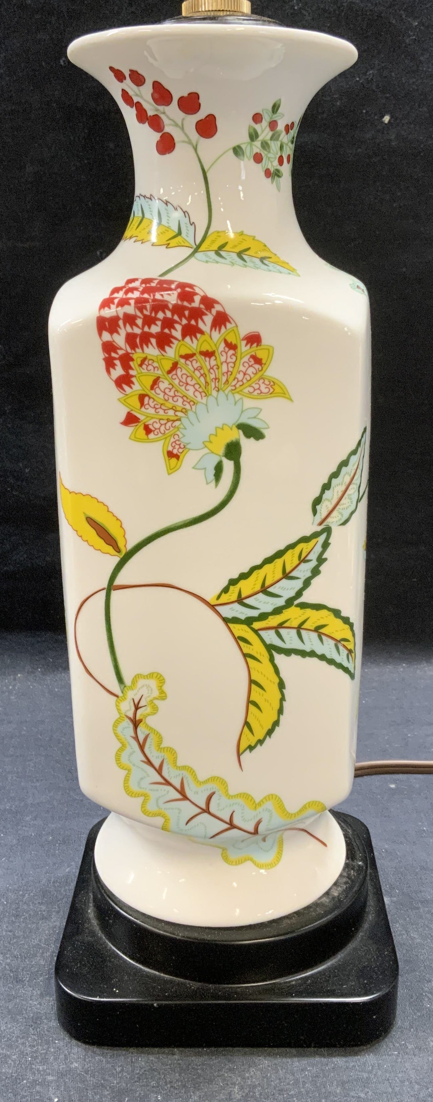White Porcelain Floral Table Lamp: White porcelain table lamp with floral motif on black base. Measures approx. 5 x 5 x 13 inches excluding finial. Not tested for function. Base is loose. Some surface wear including scratching observed