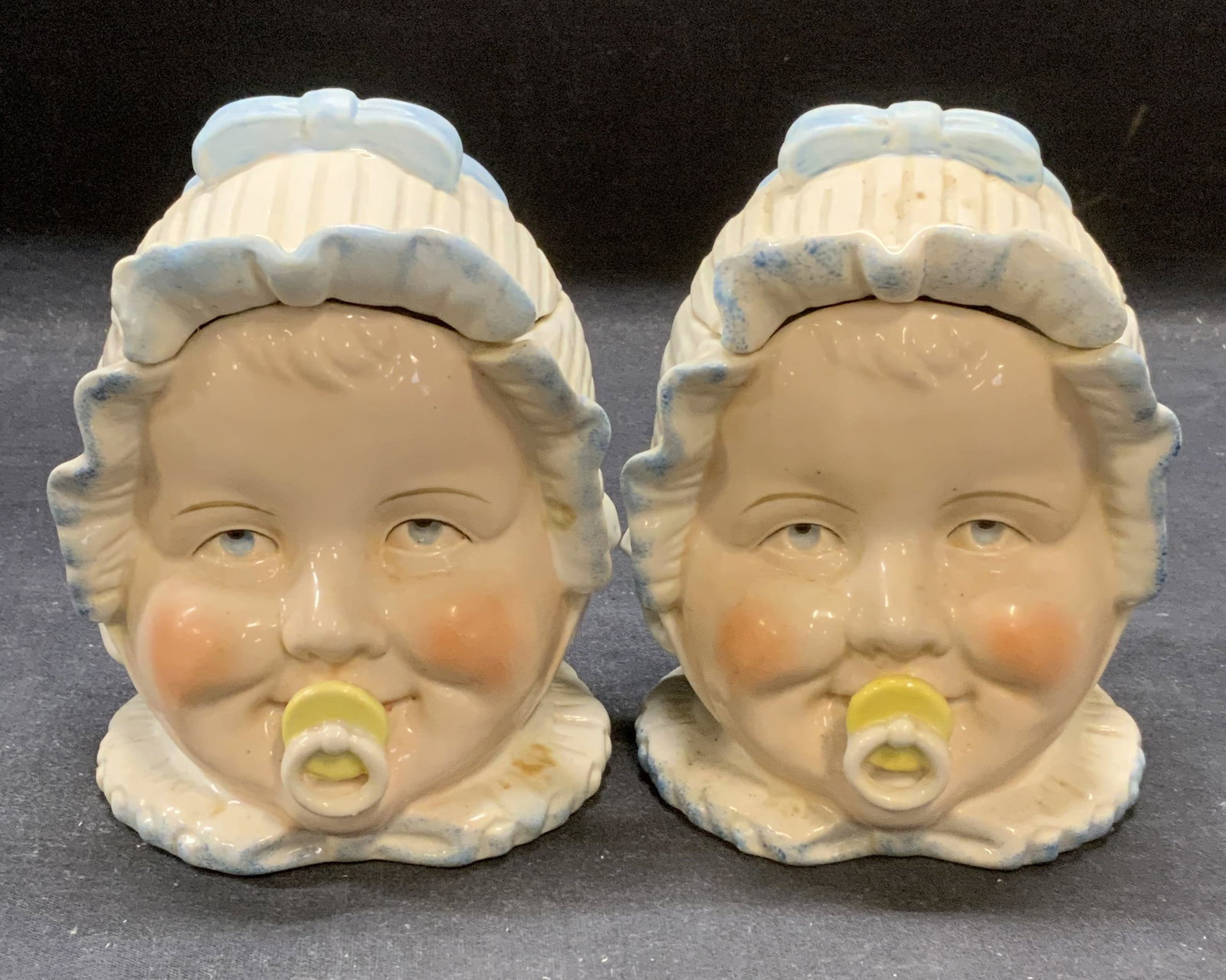 Pair Antique Porcelain Baby Head Jars: Pair of antique porcelain baby head jars in blue and white. Hand painted. Measures approx. 4 x 4 x 5.5 inches. Both pieces have some surface wear including scratching observed. Antiques, antique jars,