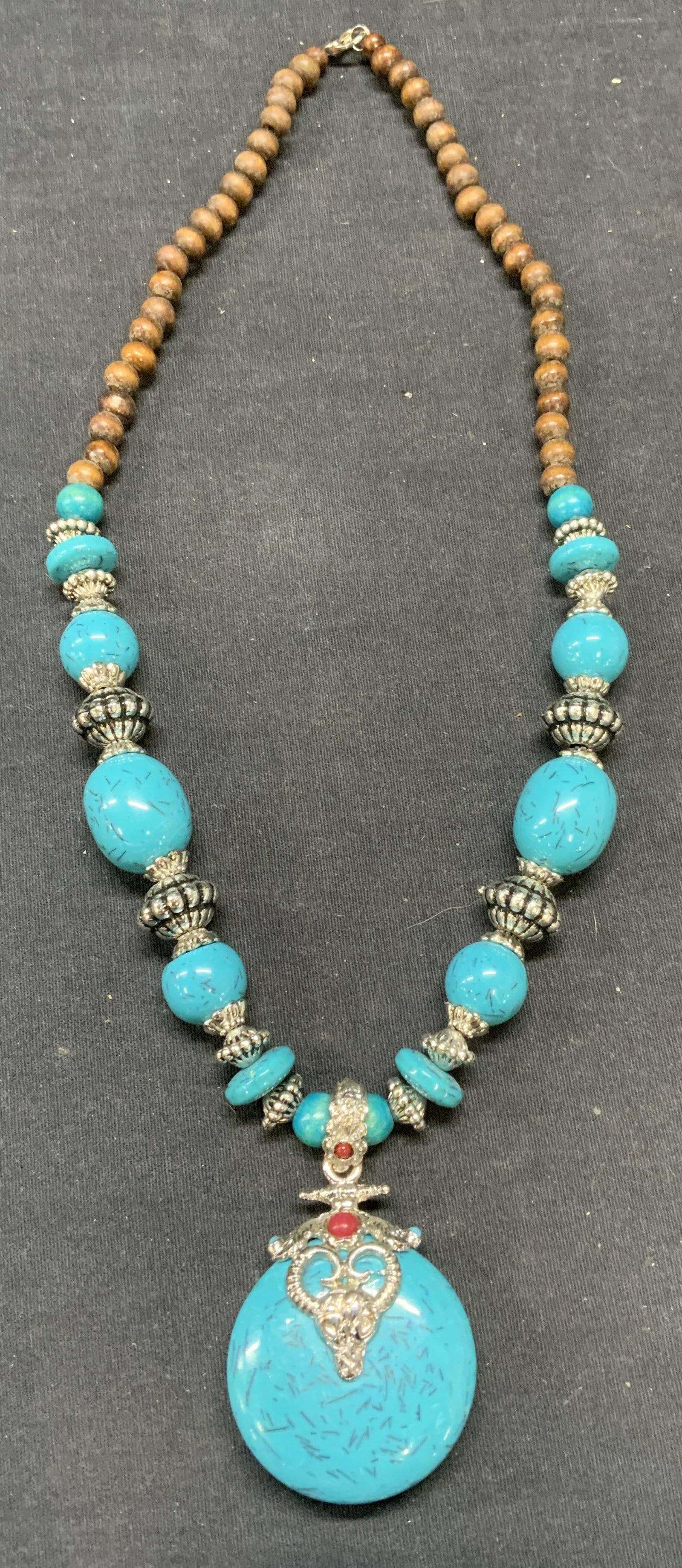 Turquoise Style Wood Beaded Pendant Necklace: Turquoise style, wood and silver tone beaded pendant necklace. Drop length approx. 11 inches. Pendant measures approx. 2.25 inches long. Some scratching observed. Estate jewelry, costume jewelry, cock
