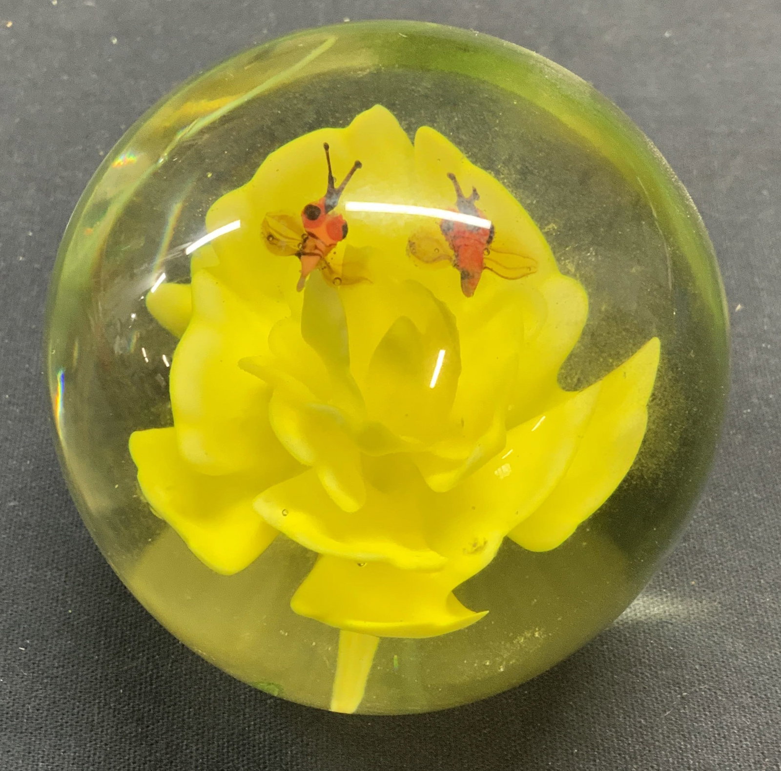 Hand Blown Art Glass Flower & Insect Paperweight: Hand blown art glass paperweight. Yellow flower and red insect motif encased in transparent glass. Measures approx. 2.75 inches wide. Some scratching observed. Art glass , Art glass paperweight, flowe