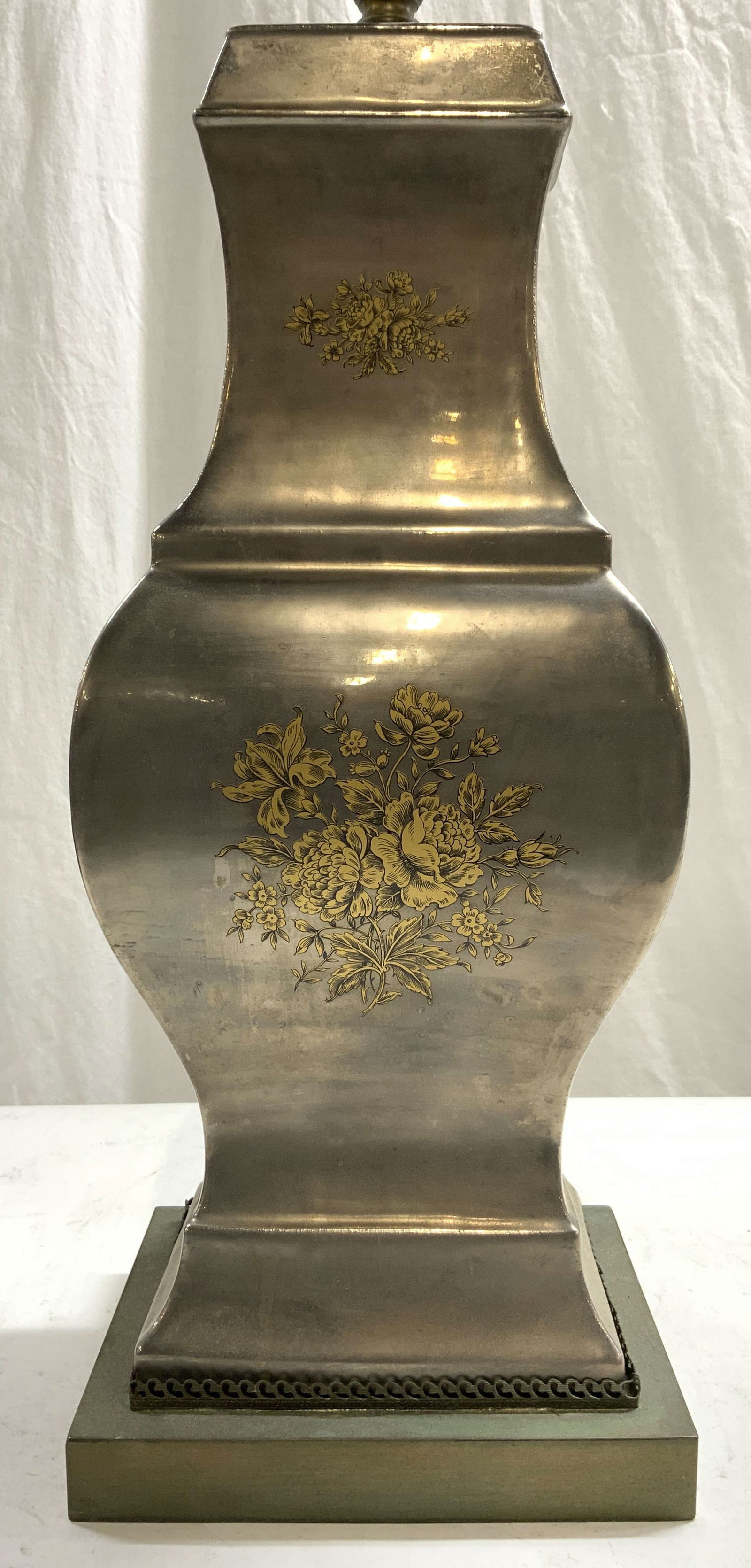 Vintage Metal Lamp W Floral Detail: Lamp is vintage. Piece is silver toned and metal with tan and back toned floral & leaf detail. Lamp has rectangular shaped metal base. Lamp includes harp and finial. Lamp measures approximately 30 inc