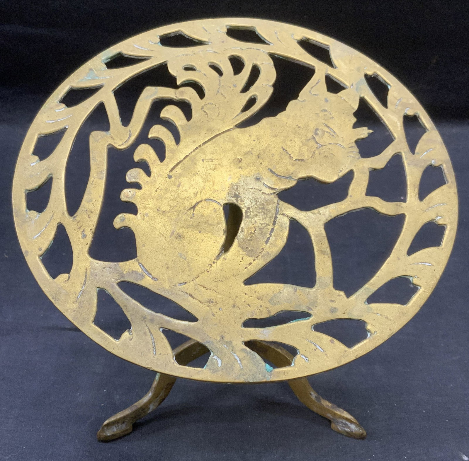 Vintage Gilt Metal Squirrel Footed Trivet: Vintage gilt metal footed trivet with squirrel motif. Pierced trivet with three feet. Measures approx. 8 x 8 inches. Scratching, loss to gilt, and bending observed. Trivet, squirrel trivet, gilt trive