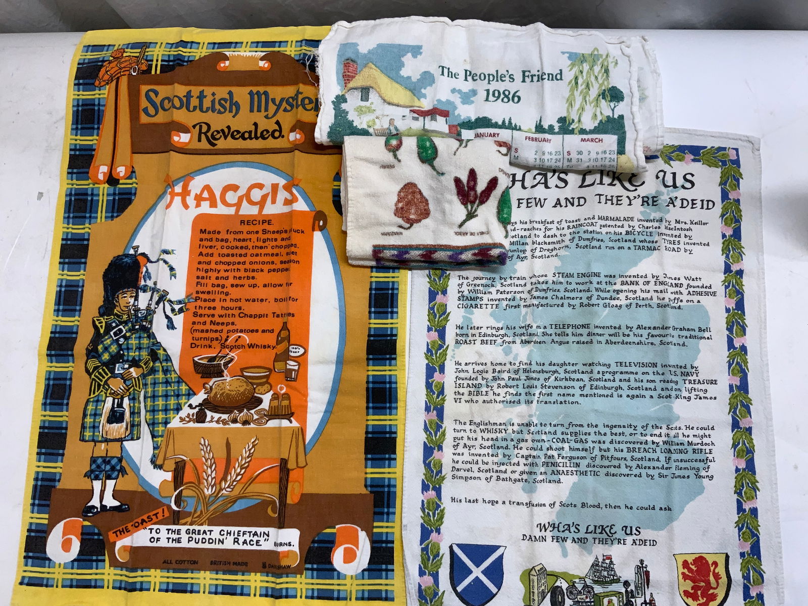 Lot 4 Cotton & Linen Vtg Scottish Tea Towels: Lot 2 Scottish motif tea towels . Colorful linen towel with Haggis recipe and Scottish Bag Piper, measures 28 x 17.75 in. Cotton towel with Scottish flag and Scottish lion symbol , measures 16.5 x 23.
