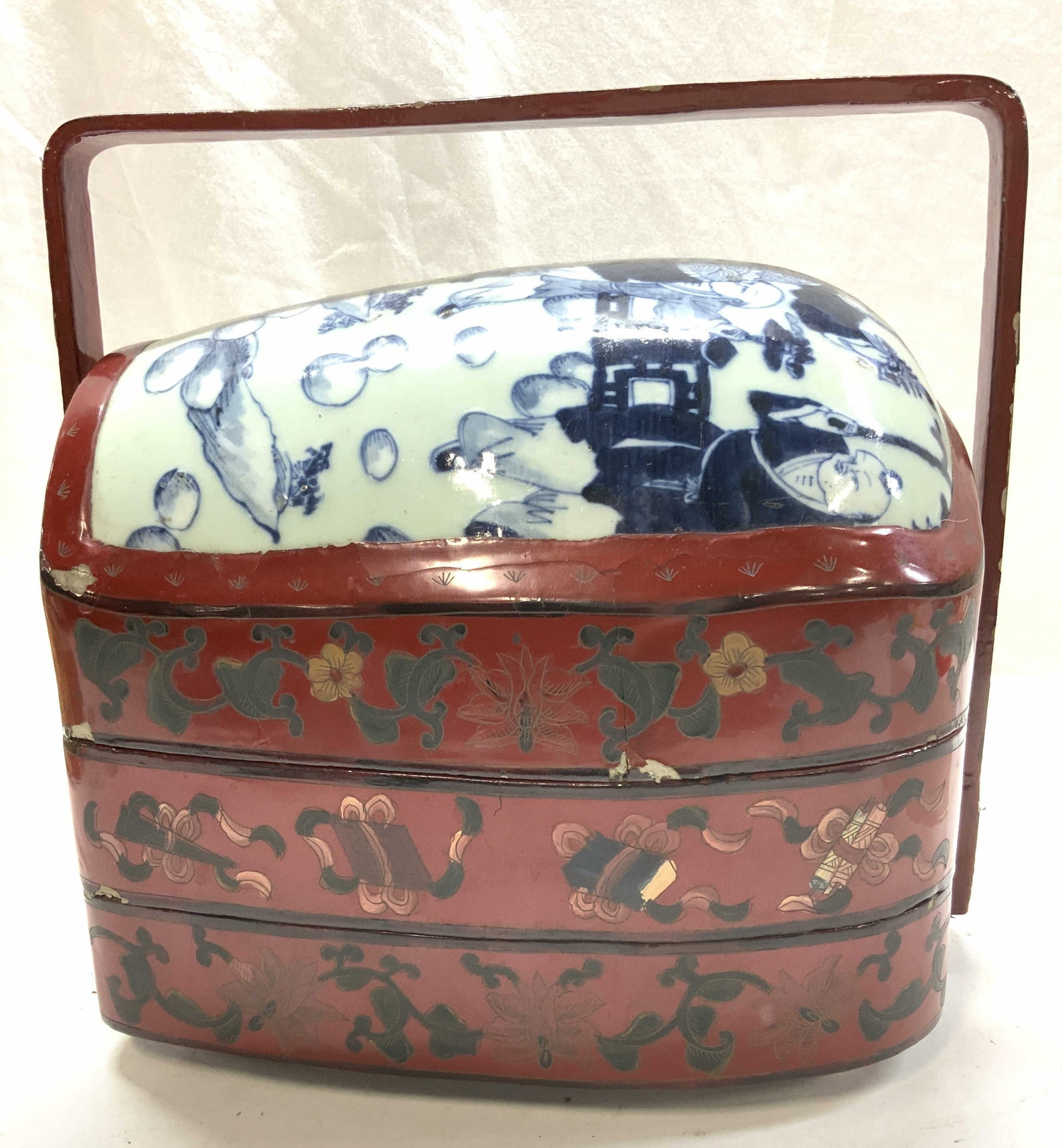 Asian Lacquered Wood and Porcelain Tiffin Box: Chinese lacquered wood and Ceylon porcelain lunch box/ tiffin box. Carry handle, hand painted , including the porcelain lid. Ceylon blue with cobalt blue Asian Figurals. Box has 2 compartments measuri
