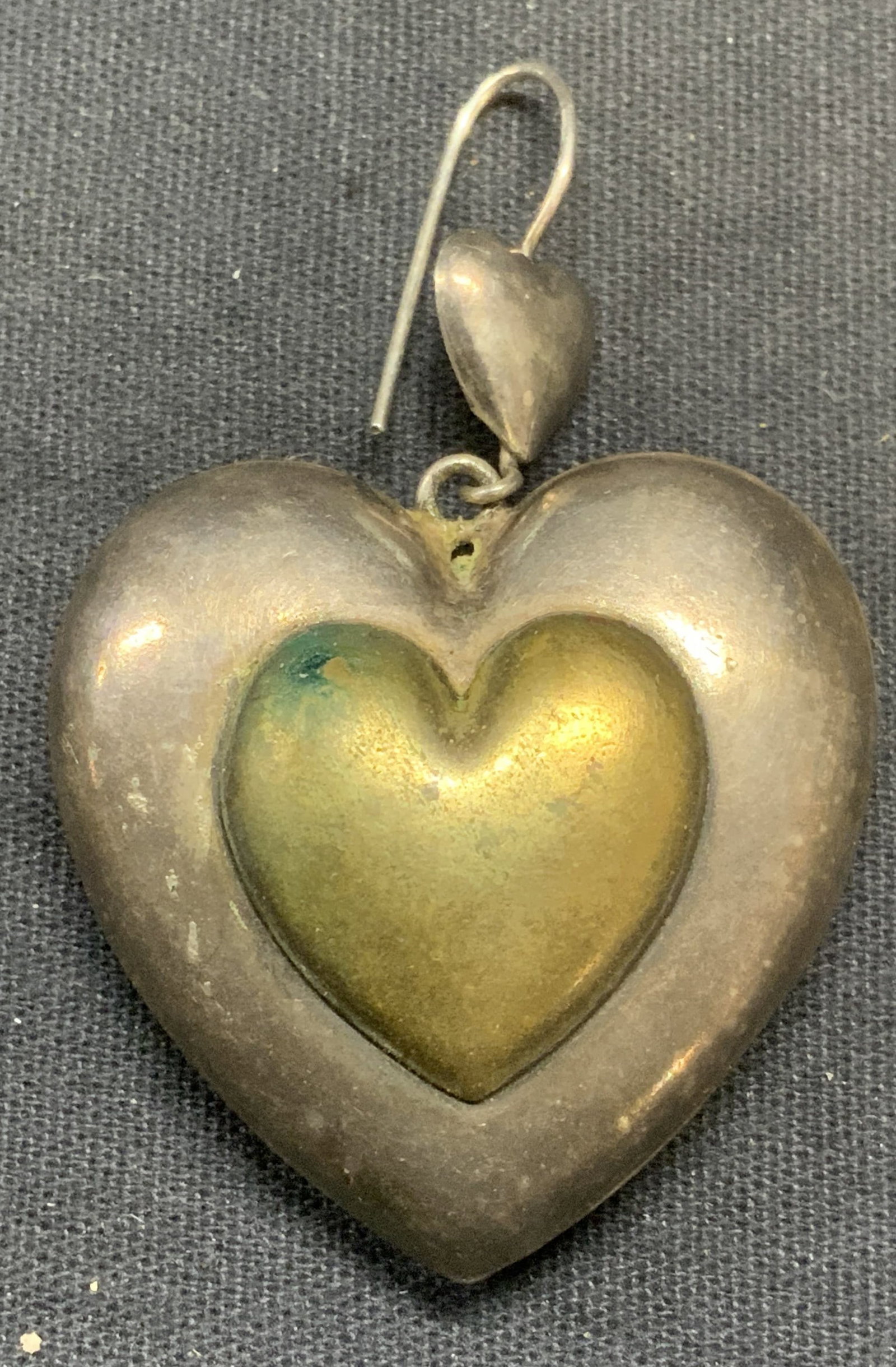 Vintage Sterling Silver Heart Earring: Vintage sterling silver heart shaped earrings. Embossed three dimensional shape. Hook backing. Single earring. Measures approx. 1 7/8 x 1 3/8 inches, total weight .35 ozt. Tests for sterling using Pur