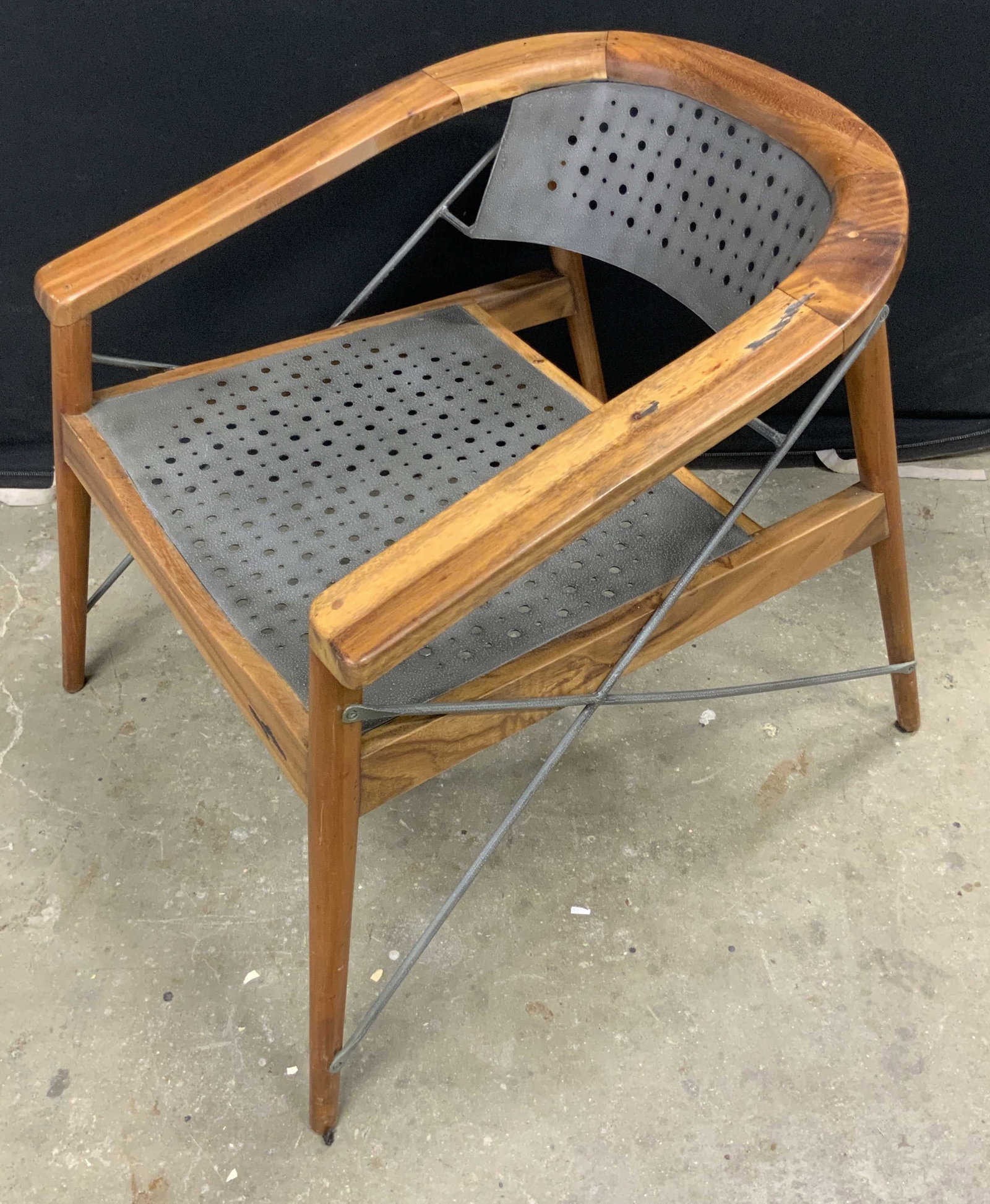 Vintage Mid Century Modern Style Armchair: A barrel back mid century modern style armchair crafted from metal and wood. Perforated metalwork to seat and back. X shaped metalwork to the sides. Tapered legs. Measures approx. 27.5H x 26D x 26.75W