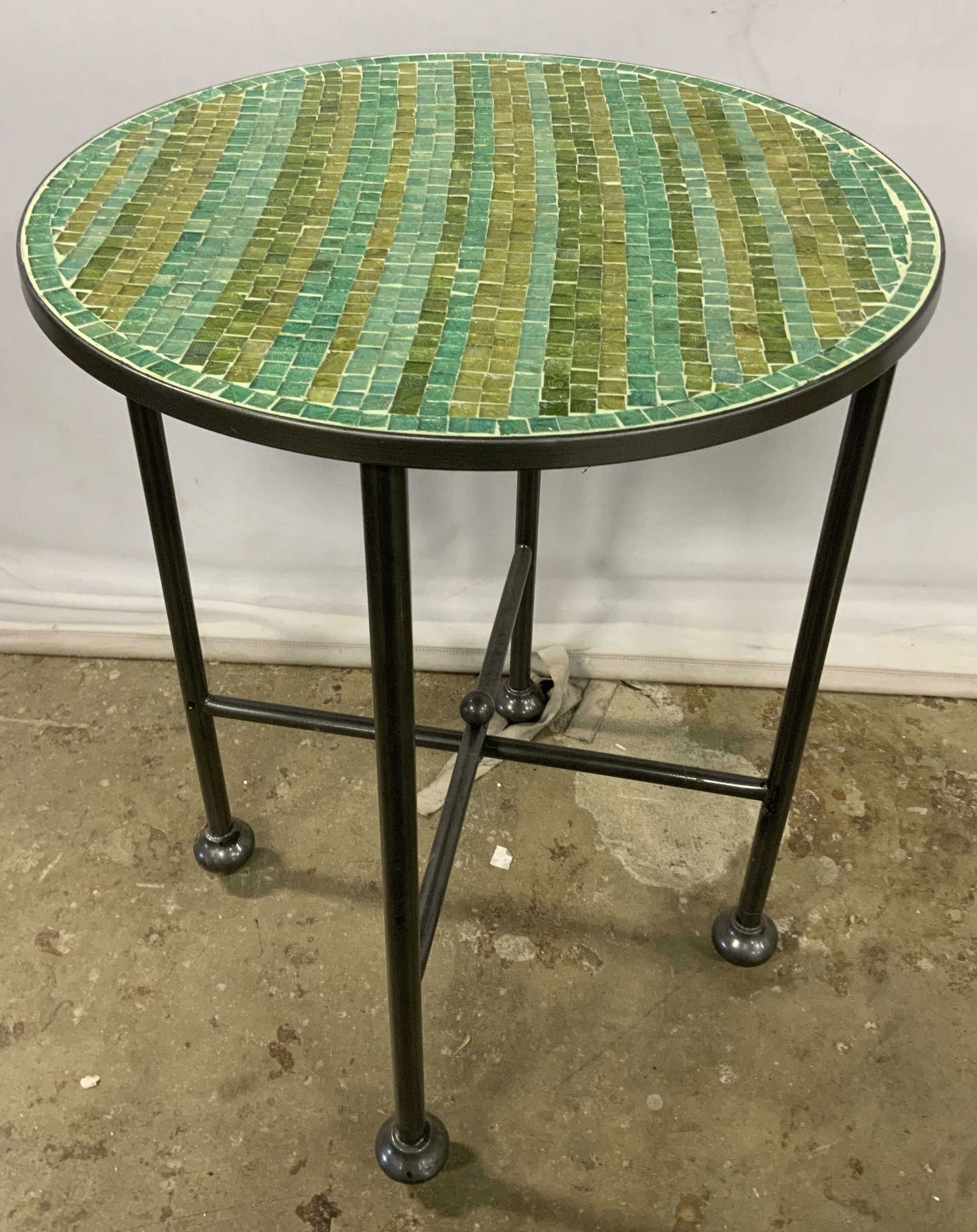 Green & Blue Mosaic Round Top Side Table: A green and blue mosaic side table featuring a round top and spherical accents towards the base. Crafted from glass and metal. Underside sticker reads PIER 1. Measures approx. 24H x 18W in. Some wobbl