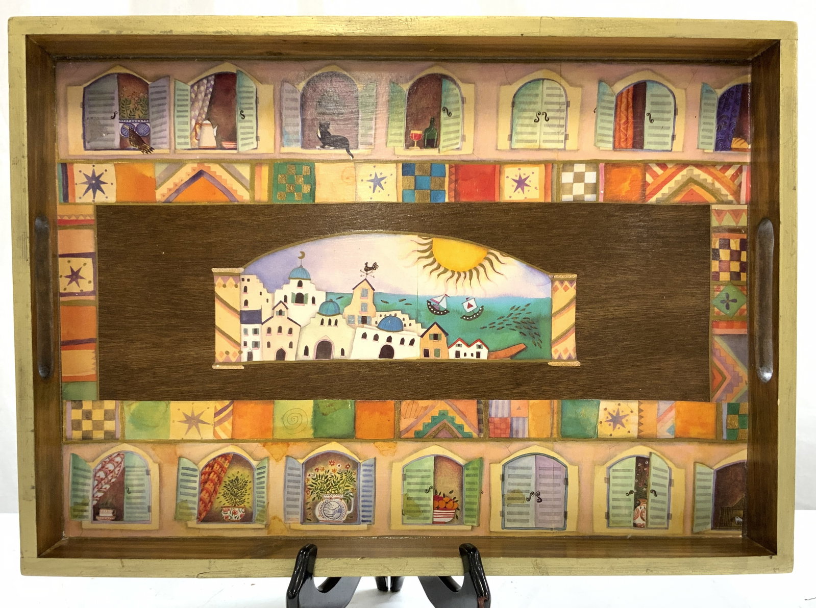 THE ESSEX COLLECTION Wooden Tray USA: Tag on underside reads THE ESSEX COLLECTION MADE IN USA. Tray is Wooden with gilt rim. Piece has pierced oval handles. Tray has printed multi toned pattern and open window detail. Tray measures approx