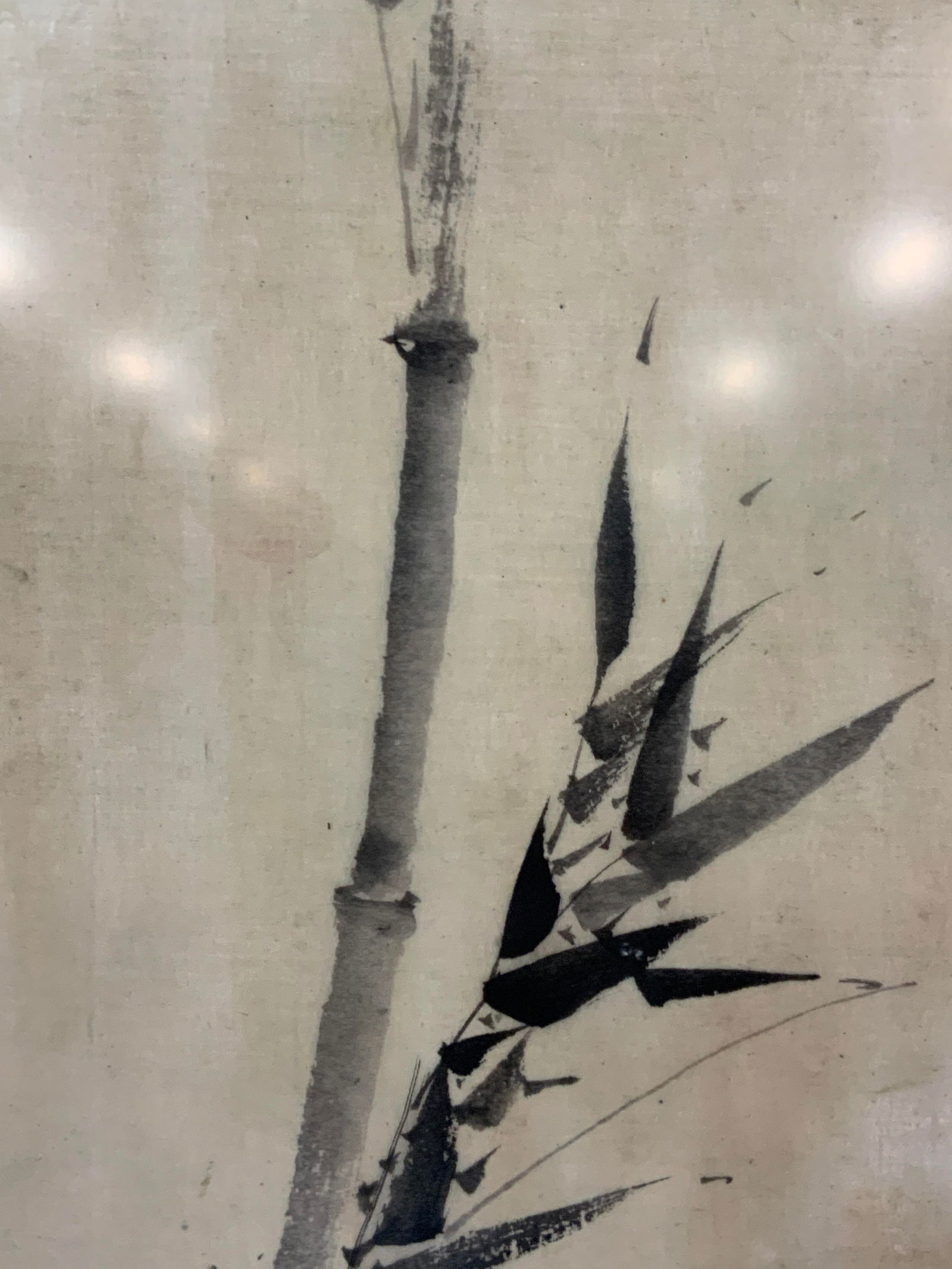 Asian Style Ink Painting Serigraph: Asian style bamboo stalk ink painting serigraph depicting a stalk of bamboo with leaf on off white background. Framed in a black wooden frame with white mat board, approx 36 x 25 inches window measure