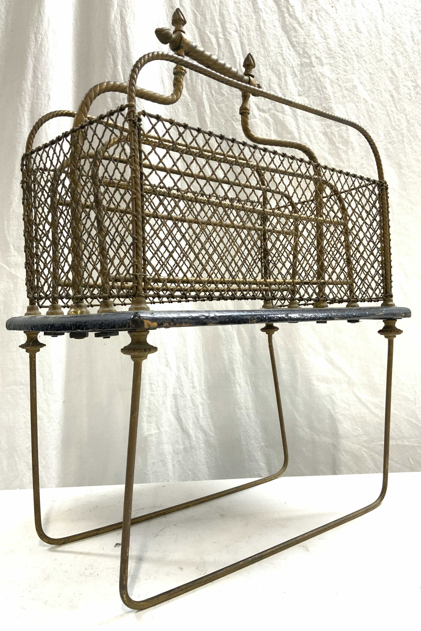 Vtg Victorian Edwardian Canterbury Magazine Holder: Magazine holder is vintage. Piece is gilt metal and wooden. Piece has diamond shape woven net style structure. Piece has barely twist style handle. Canterbury sits on 2 supports. Black toned area appe