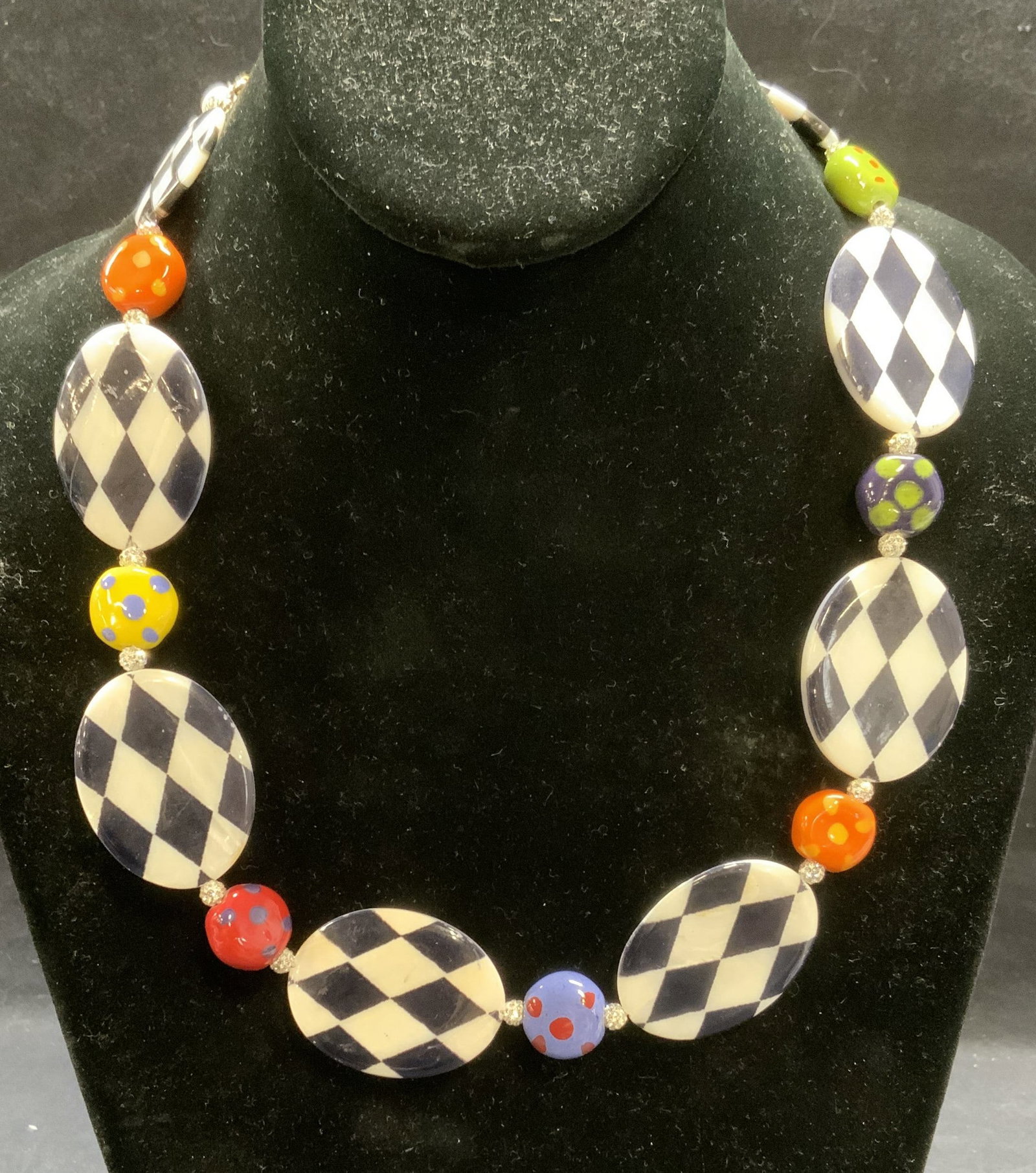 Signed Mother of Pearl Beaded Necklace: Mother of pearl, multi color bead, and crystal necklace. Signed CS on hang tag. Drop length approx. 9 inches. Some surface wear including scratching observed. Estate jewelry, costume jewelry, cocktail