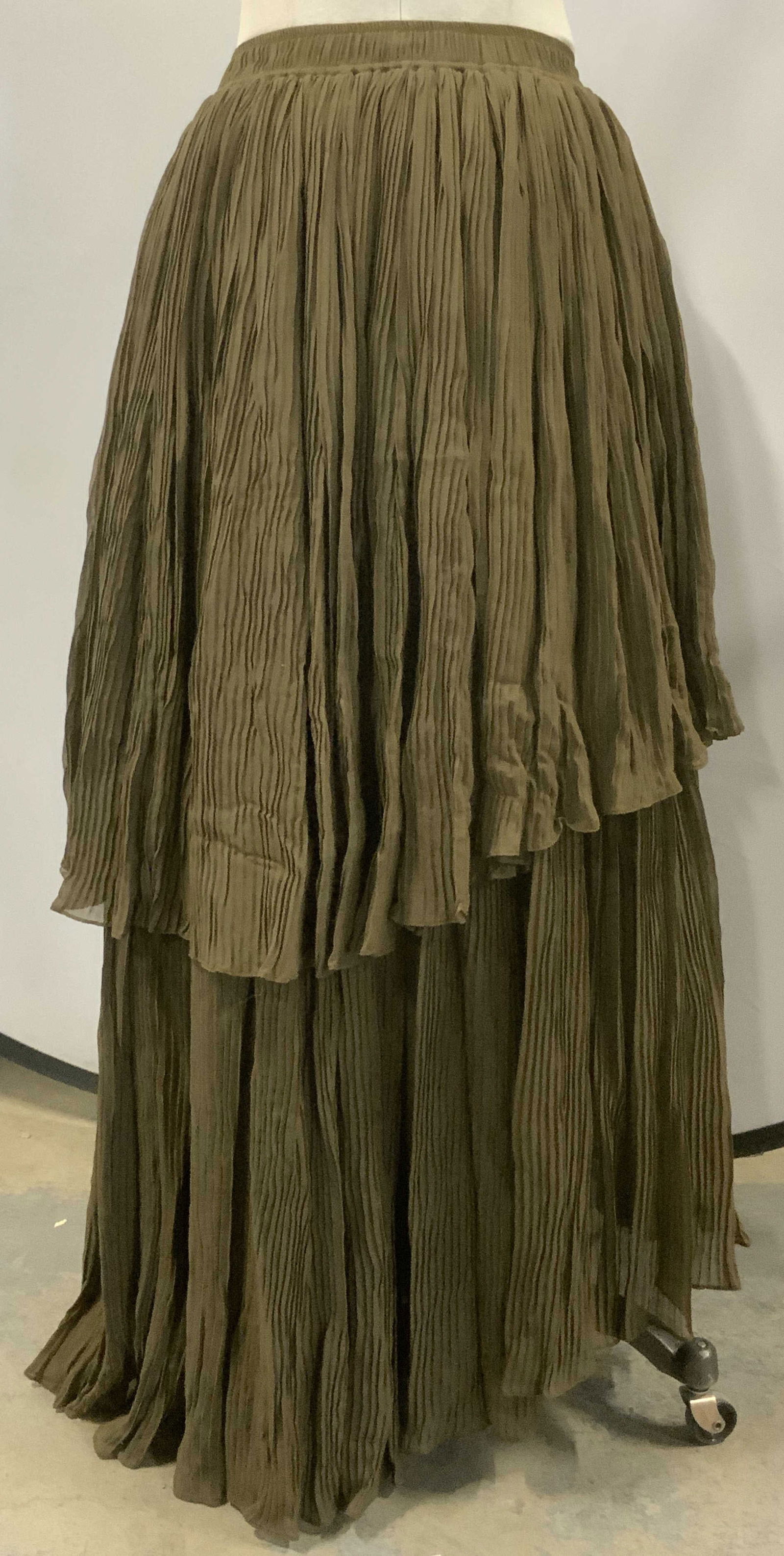 Pleated Long Length Skirt w Tulle: Long length pleated skirt in olive. Layered pleated fabric with underside tulle, giving it full body. Elastic waist, 28-35 in. Waist. 39 in. Long. Longer in back. Possibly silk. No label. Pleated skir