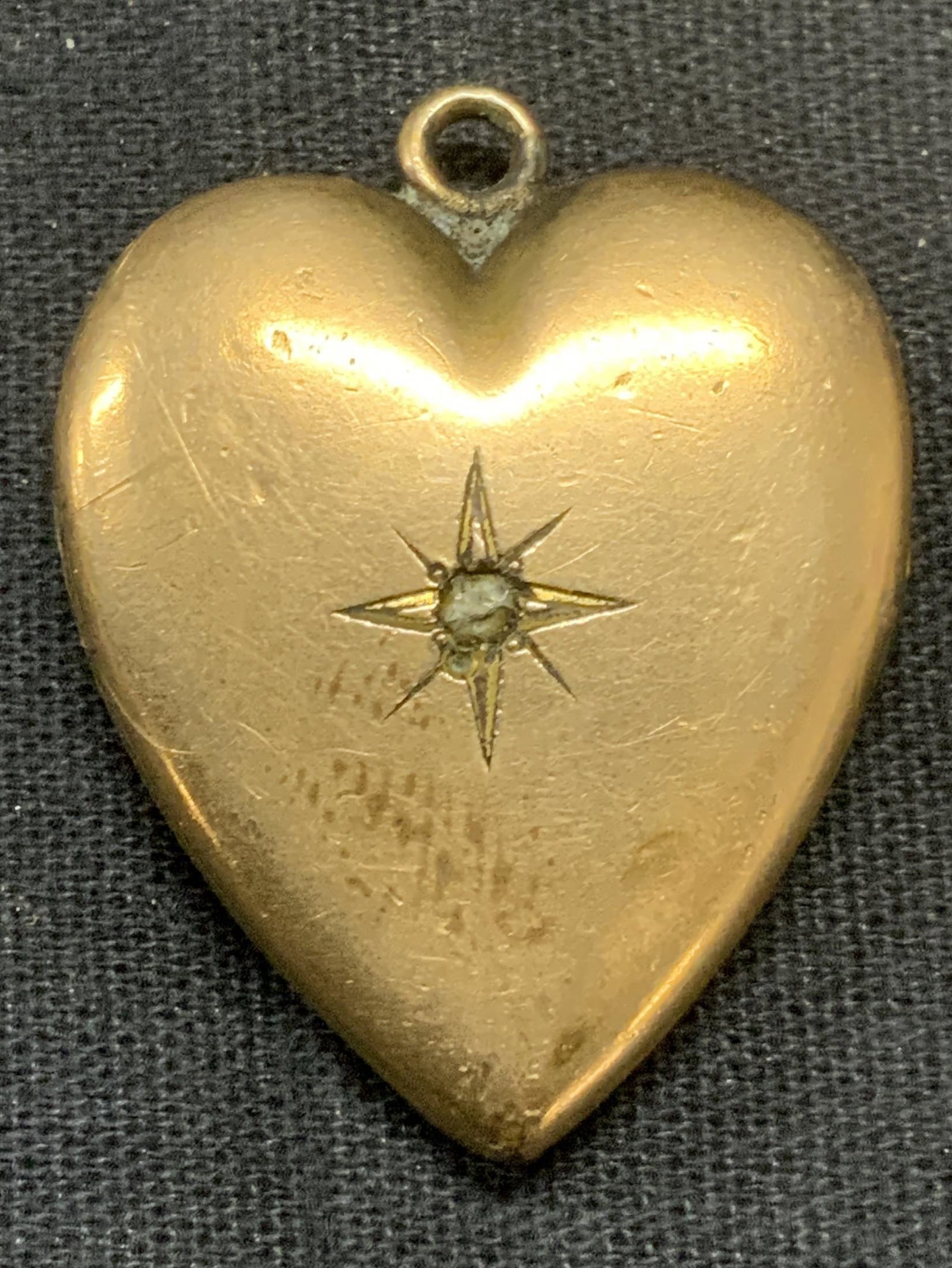 Antique Gold Filled Heart Locket: Antique gold filled heart locket with etched radiating pattern and monogram to reverse. Interior contains antique photograph. Measures approx. 1.25 x 1 inches. Some surface wear including scratching o