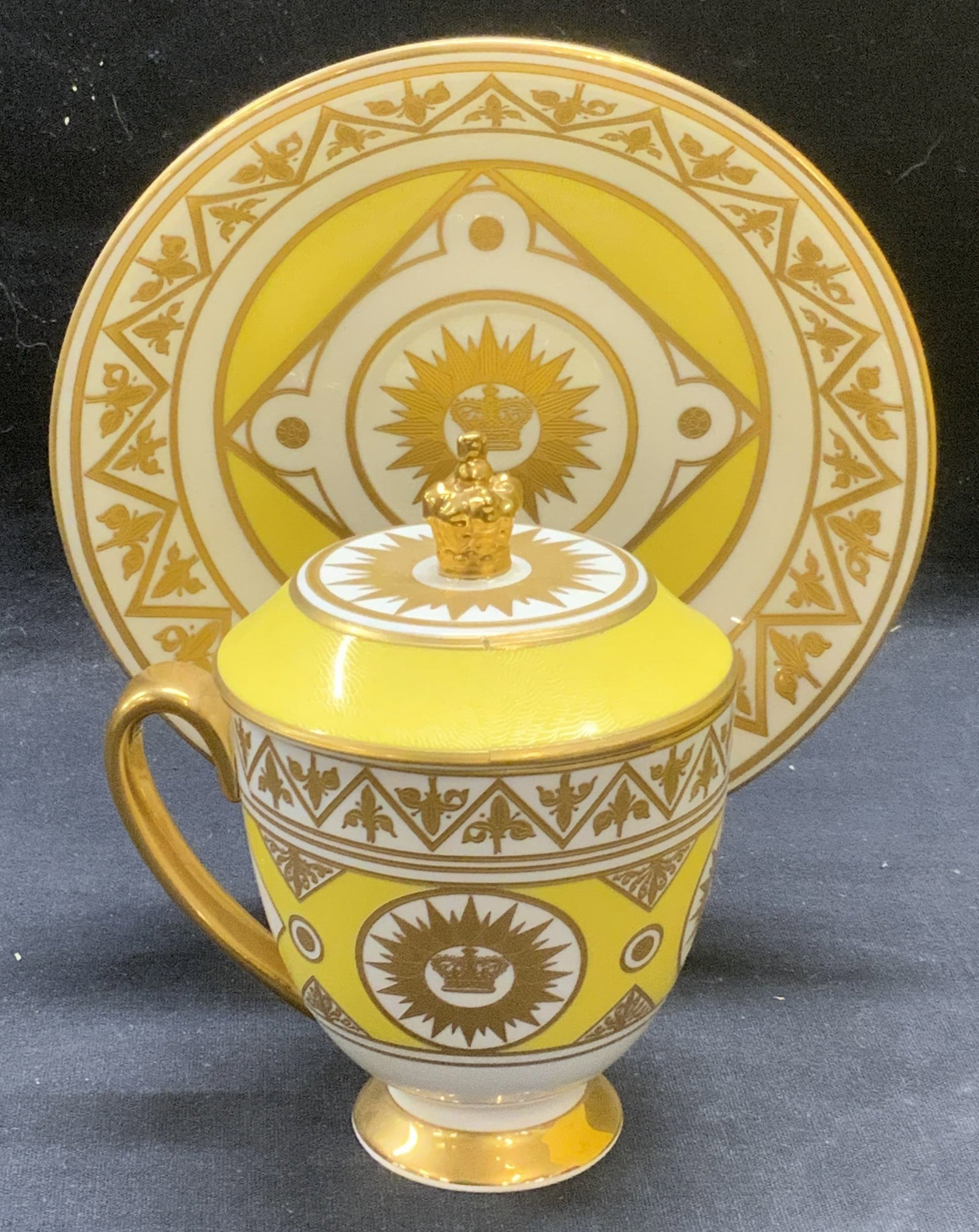 Royal Collection China Ltd Edt Chocolate Cup: The Royal Collection fine bone china 2008 limited edition chocolate cup and saucer set with original box. Lidded cup with matching saucer in yellow and white with gilt decoration. Trademarked to under