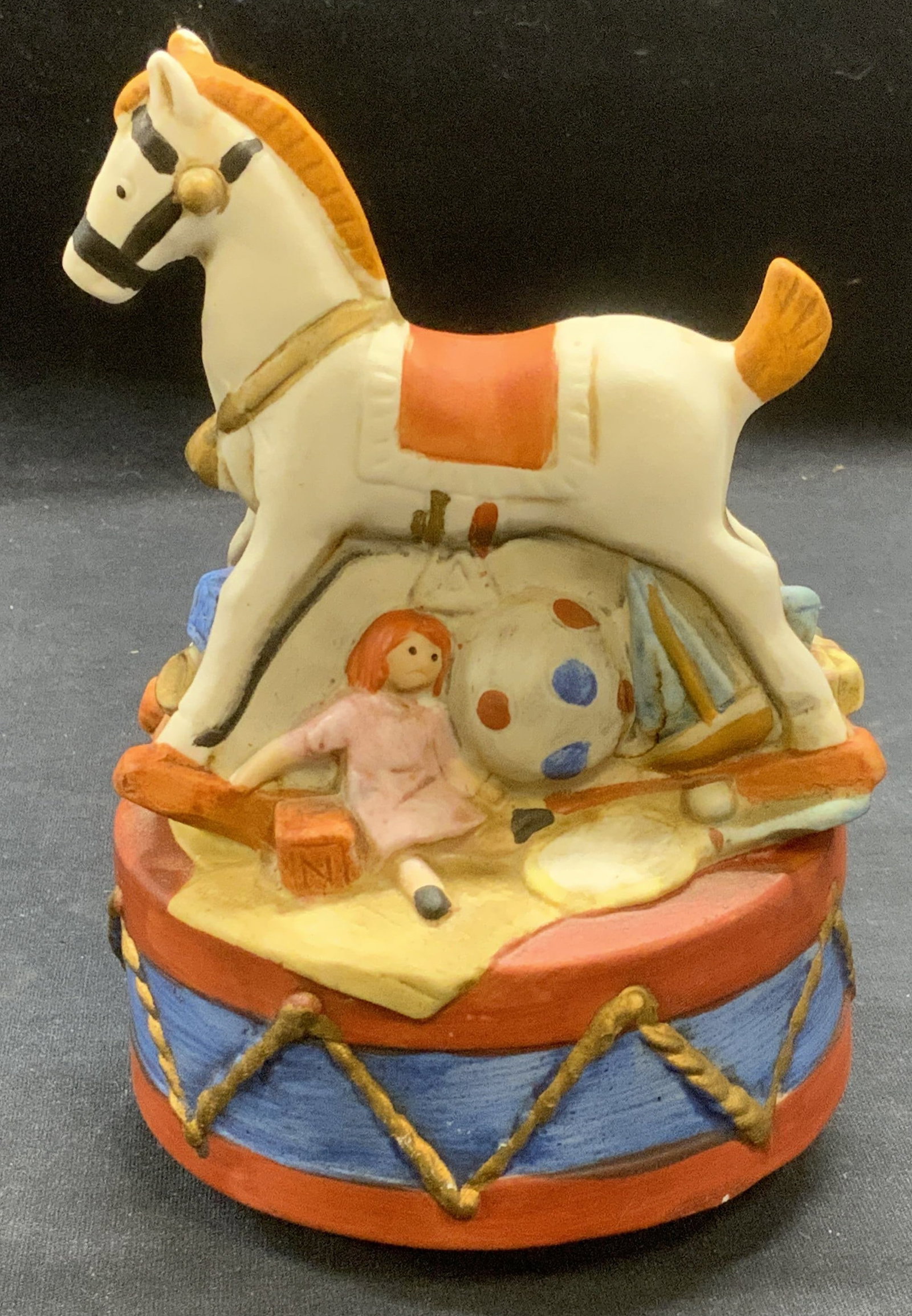 Vintage Ceramic Rocking Horse Music Box: Vintage ceramic rocking horse music box. Hand painted. Box spins on base. Measures approx. 4.25 x 6.5 inches. Some surface wear including scratching and previous repair observed. Not tested for functi