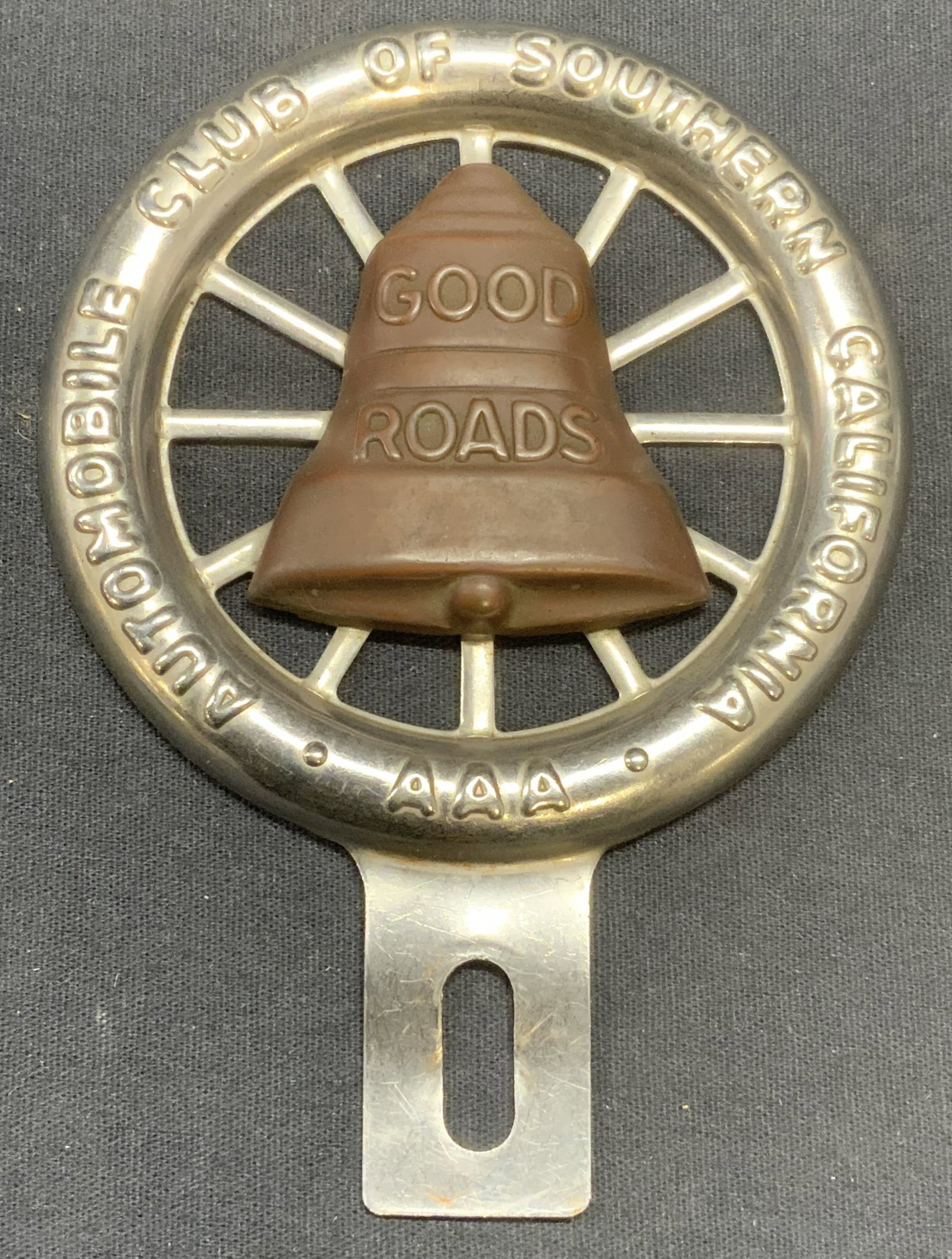 Vtg AAA Good Roads California License Plate Topper: Vintage AAA Automobile Club of Southern California metal license plate topper with wheel and bell motif. Reads Good Roads. Measures approx. 5 x 3.75 inches. Aaa, aaa automobile club, automobile club o