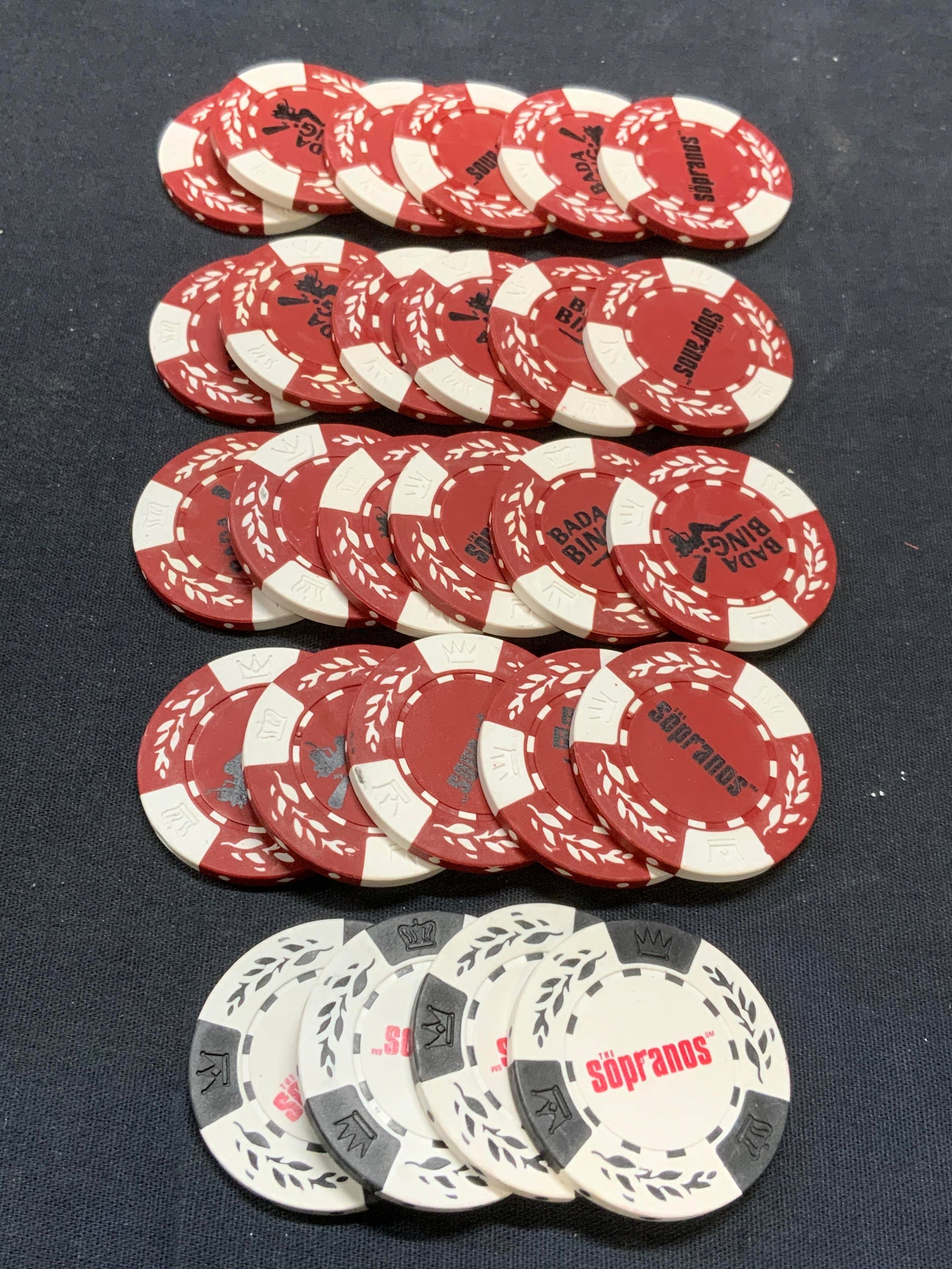 Set 27 The Sopranos Poker Game Chips: Set of 27 Sopranos poker game chips. 23 red and 4 black. Read Sopranos and Banda Bing. Measure approx. 1.5 inches diameter each. Composite material. All pieces have some surface wear including scratch