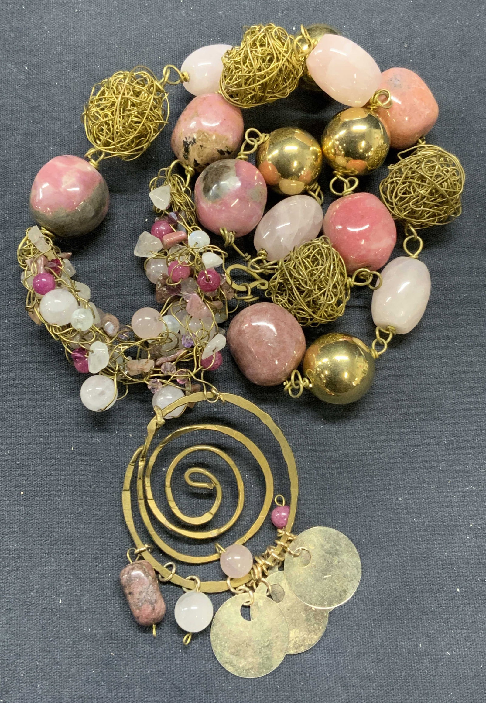 Gold Tone Heavy Rhodonite Beaded Necklace: Vintage gold tone pink gemstone beaded pendant necklace. Possibly rhodonite and Quartz. Drop length approx. 12 inches. Pendant measures approx. 3 inches long. Total weight 233.3 grams. Some scratching