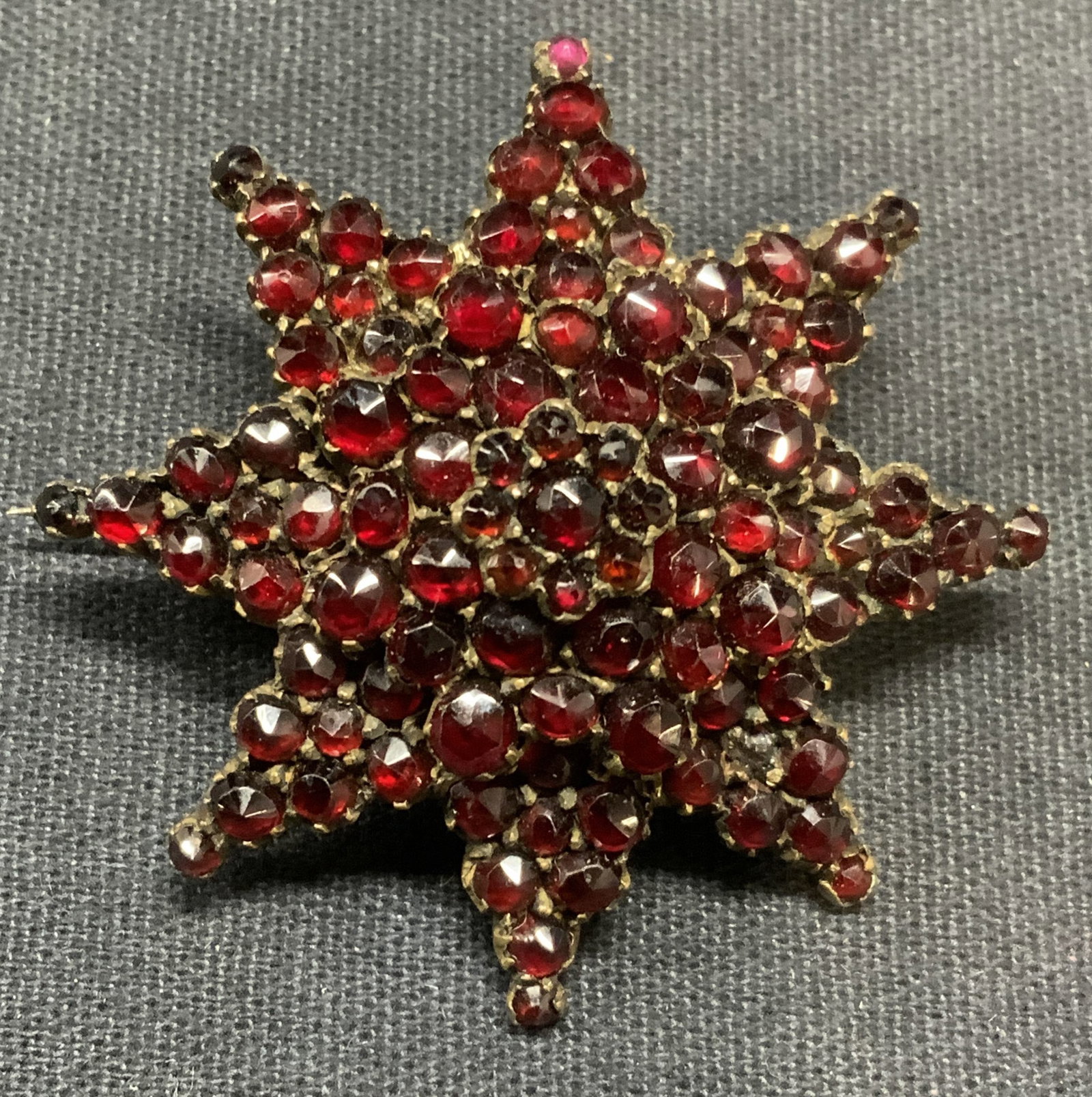 Vintage Garnet Flower Brooch: Vintage garnet flower brooch. Hinge pin to underside. Measures approx. 1.75 inches wide. Some surface wear including scratching observed. Some surface wear including scratching observed. Estate jewelr