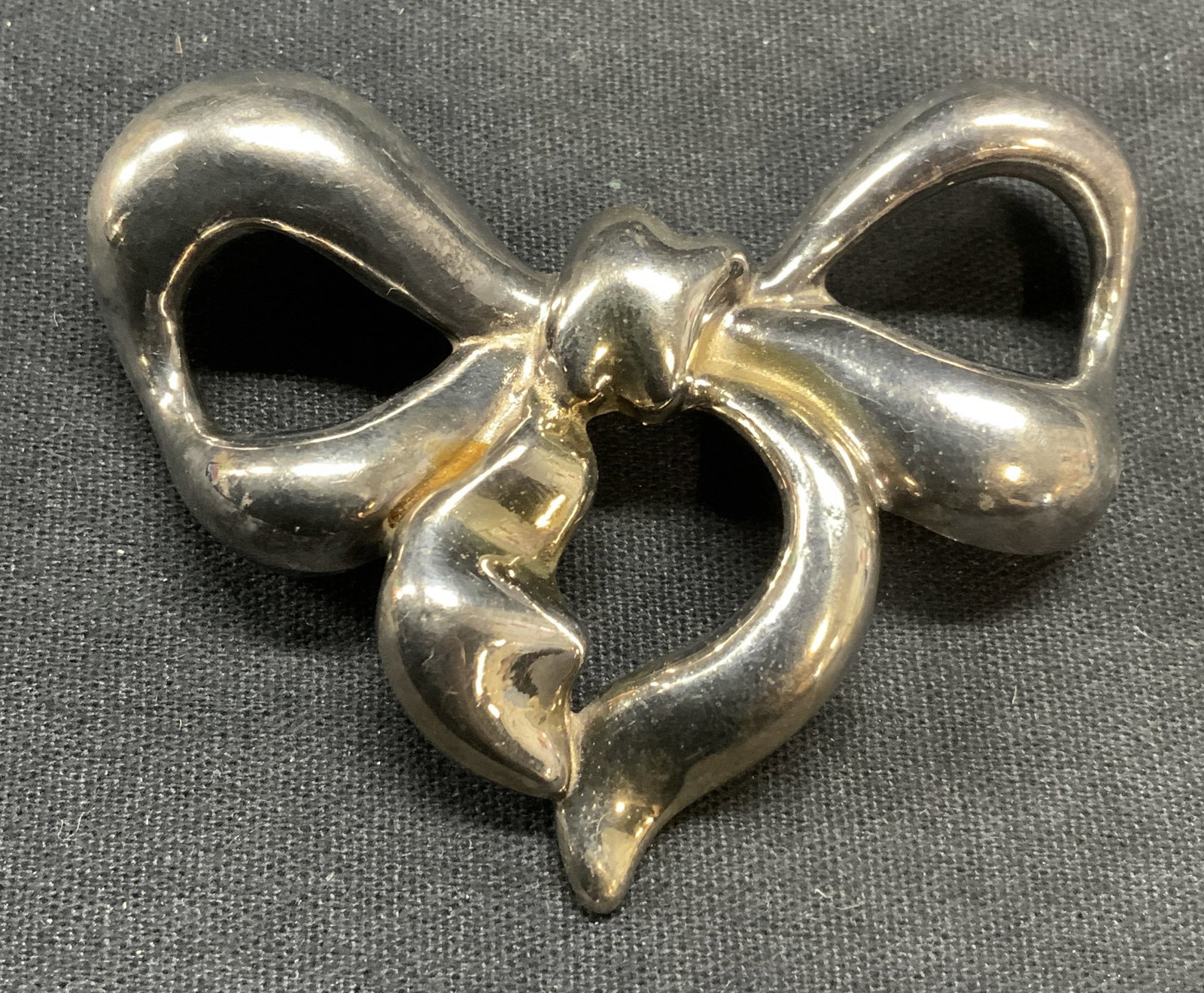Vintage Sterling Silver Bow Brooch: Vintage sterling silver ribbon bow form brooch. Marked 925 to underside. Hinge pin to underside. Measures approx. 2.25 x 2 5/8 inches. Total weight .42 ozt. Some scratching observed. Estate jewelry, f
