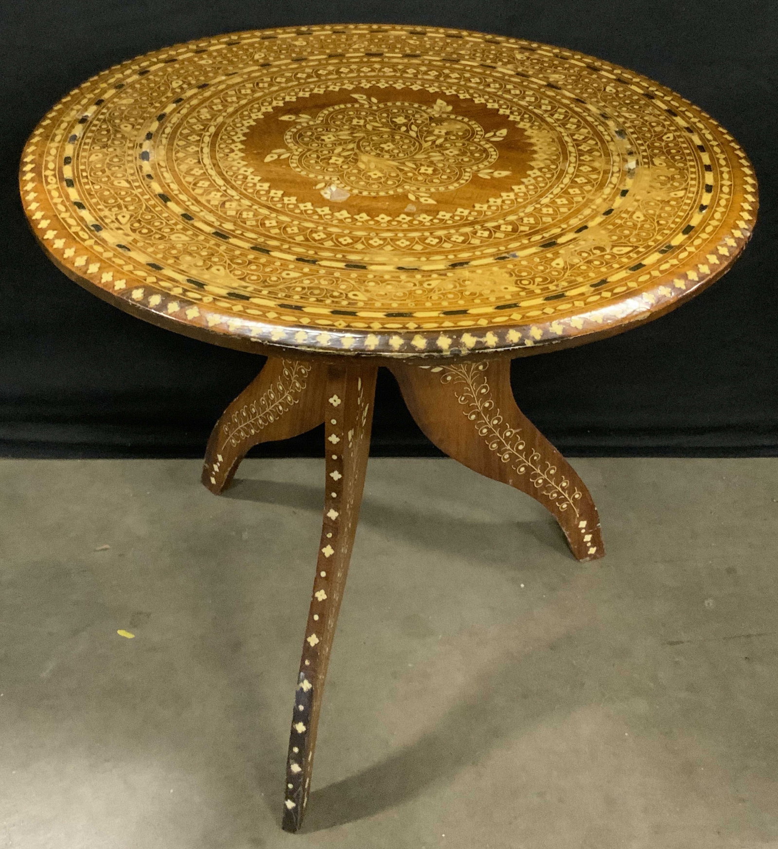 Vintage Bone Inlay Round Top Wooden Side Table: A vintage wooden round top side table featuring white and black bone inlay. Appears to be bone, possibly shell or composite material. Three curved legs to the base. Measures approx. 20H x 18W in. Some