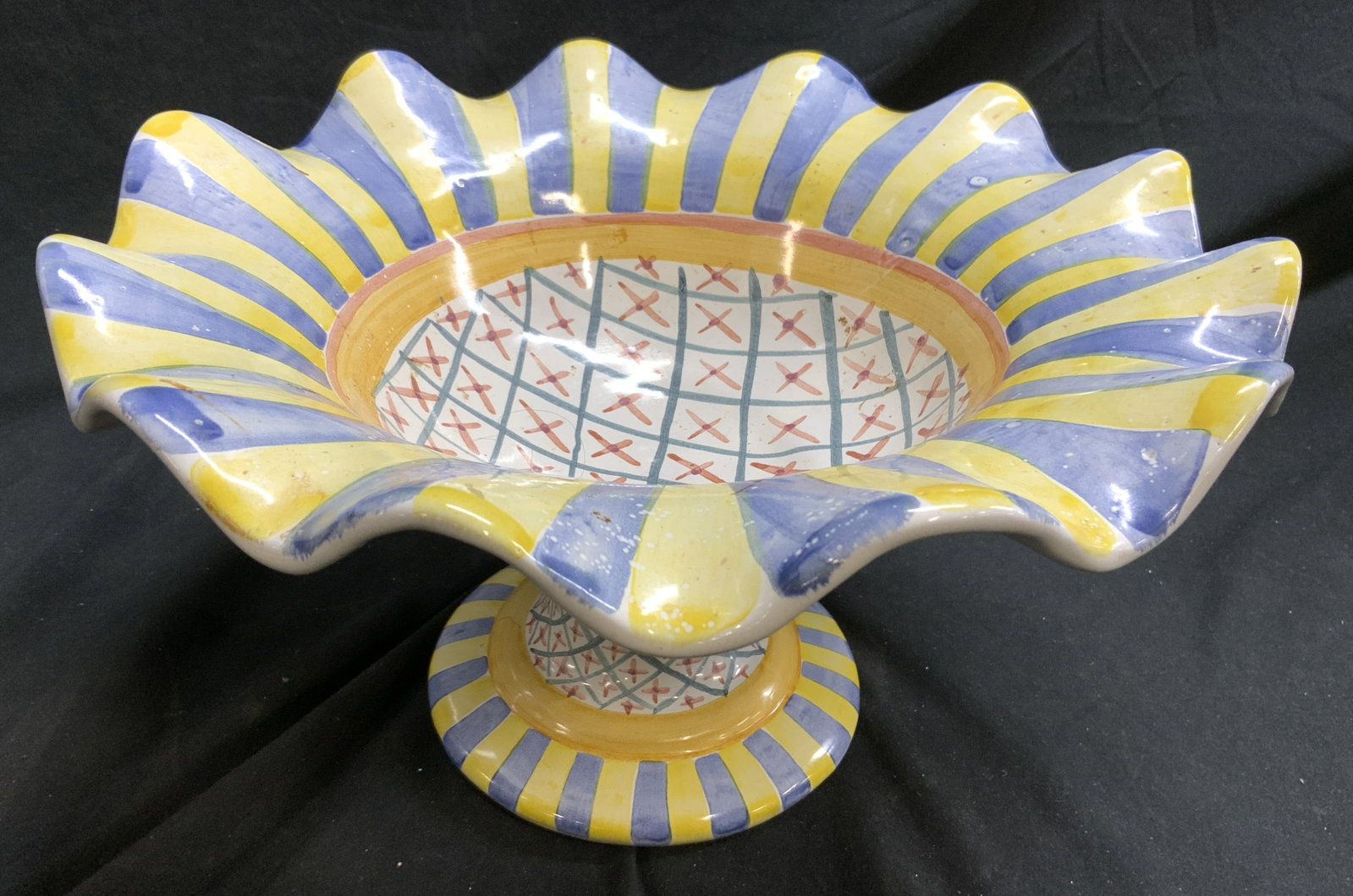 MACKENZIE CHILDS MONET Ceram Ruffled Footed Vessel: Underside inscribed MACKENZIE CHILDS & marked MONET. Vessel is ceramic, appears to be hand crafted. Piece has ruffled handkerchief style rim. Vessel has multi toned geometric, stripe & x pattern detai