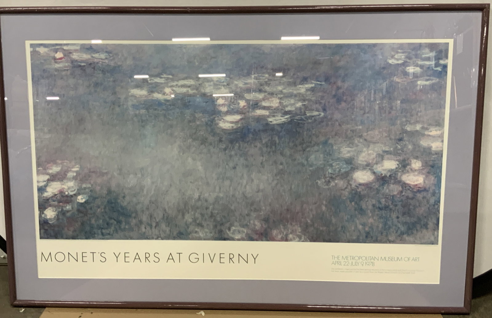 The MET 1989 Monets Years At Giverny Advert 56in: The metropolitan museum of art, April 22- July 9, 1978 Monets years at Giverny depicting The water lilies. Published 1989 Framed in a purple toned metal frame with lavender toned mat board. Approx 36 