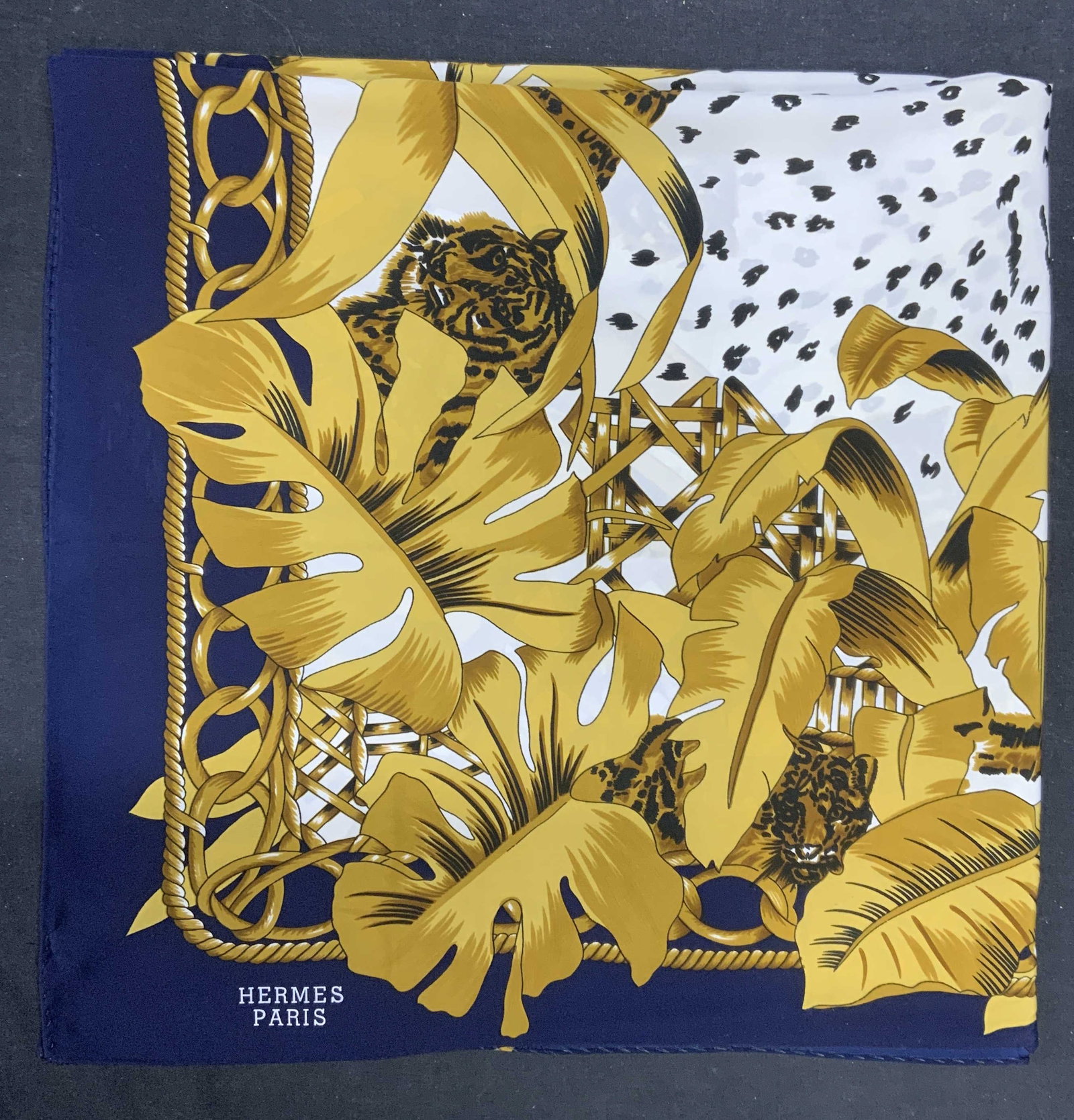 Hermes Silk Blue & White Tiger Scarf: Hermes silk scarf with tiger and cheetah motif in blue, white, gold, and black. Hand rolled edges. Material feels like silk. Signed Hermes Paris to lower left corner. Measures approx. 34 x 34 inches.