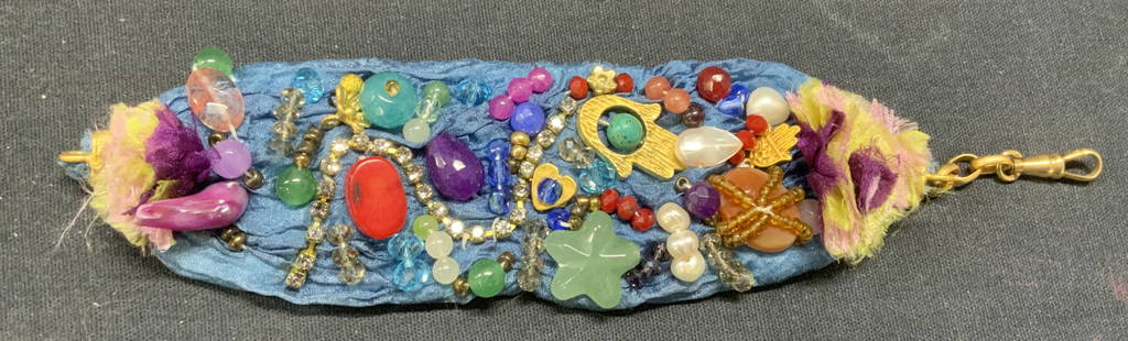 Handmade Beaded Gem & Crystal Bracelet: Handmade blue fabric bracelet with multi color beaded gemstone, pearl, crystal and charm decoration. Measures approx. 7 inches long. Some surface wear including scratching observed. Estate jewelry, co