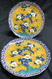 Pair Signed Asian Porcelain Plates: Undersides of each plate are signed with red toned Asian characters. Each plate is porcelain. Interiors have multi toned floral, leaf and bird detail, vine detail around rims. Each plate measures